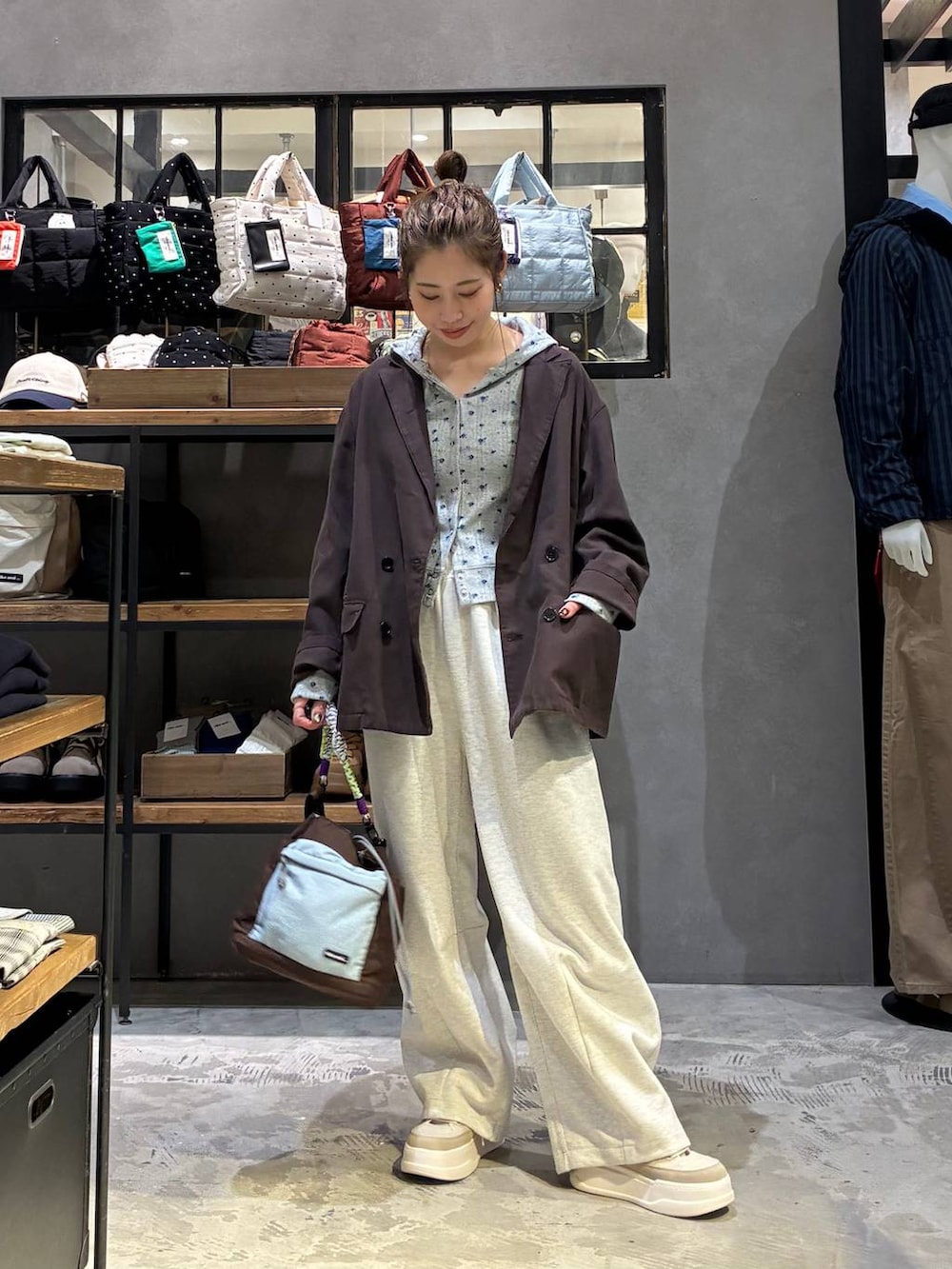 グレー系のスウェットパンツ、ベージュ系のスニーカー、その他のショルダーバッグを着用したレディースの冬コーディネートの6枚目の写真