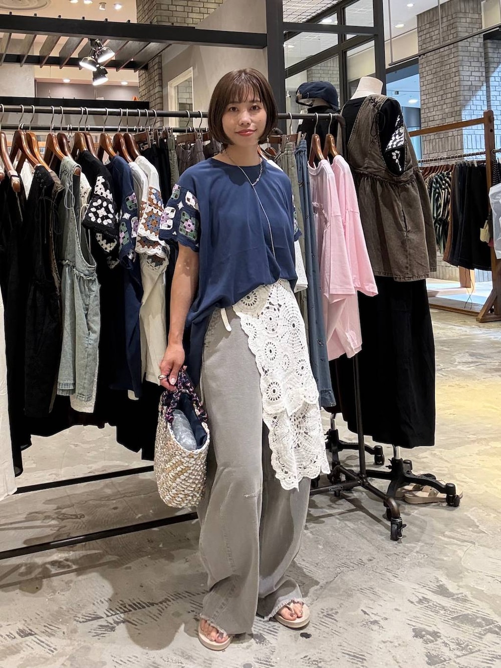 グレー系のその他パンツ、ベージュ系のサンダル、グレー系のかごバッグを着用したレディースの夏コーディネートの5枚目の写真