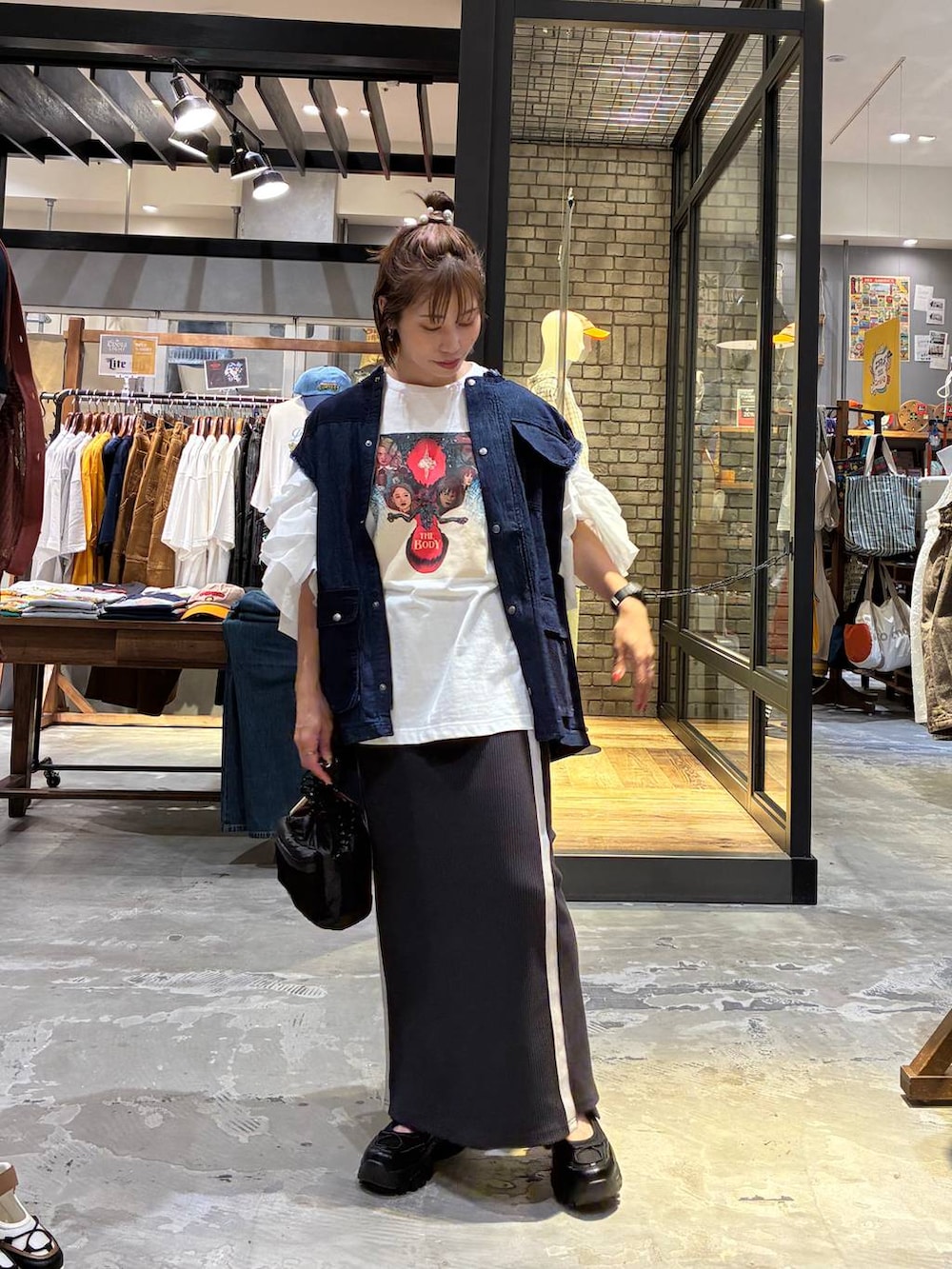 ホワイト系のスカート、ブラック系のスニーカー、ホワイト系のTシャツ/カットソーを着用したレディースの夏コーディネートの4枚目の写真