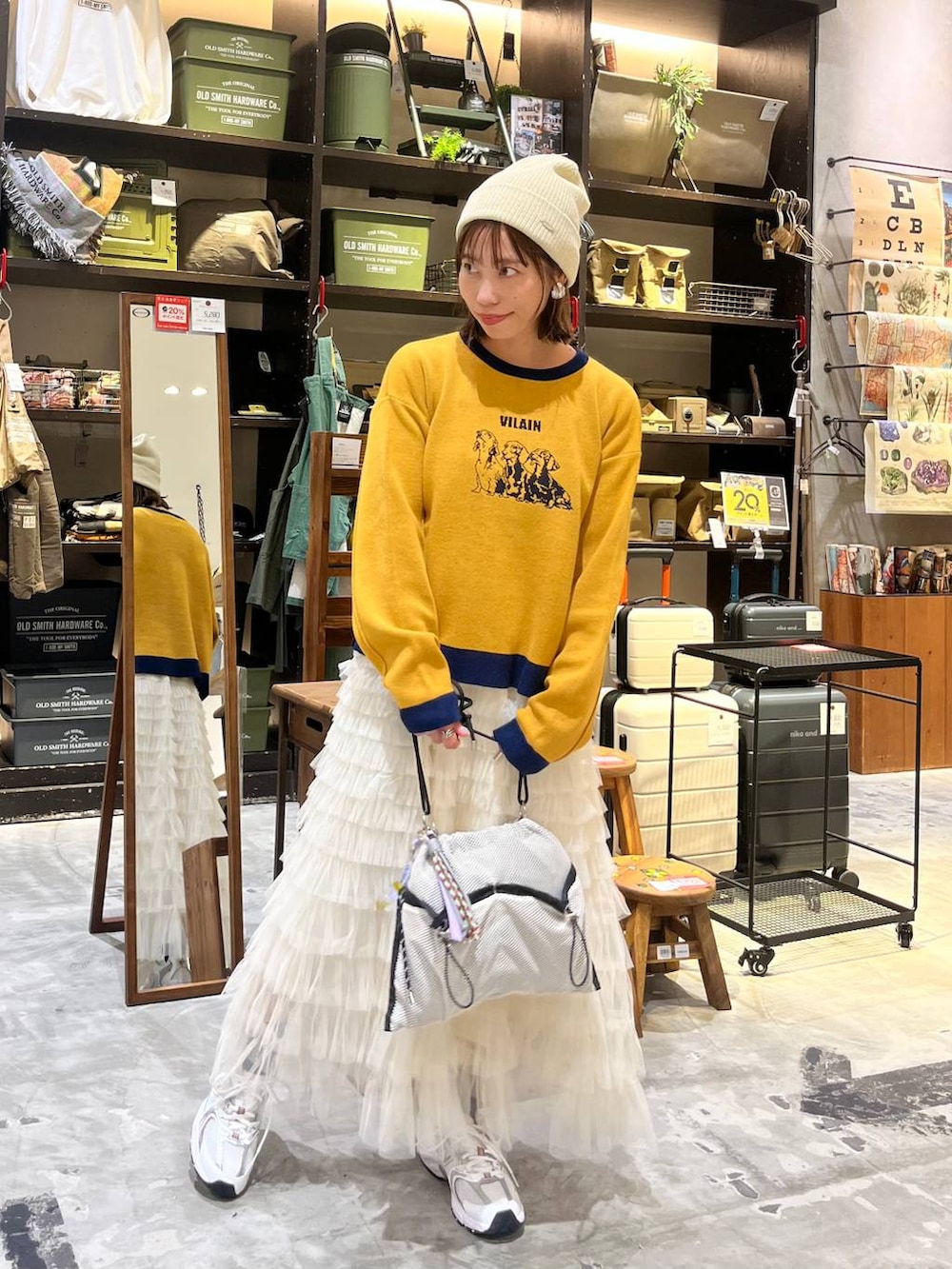 ホワイト系のスニーカー、グレー系のショルダーバッグ、ホワイト系のスカートを着用したレディースの秋コーディネートの4枚目の写真