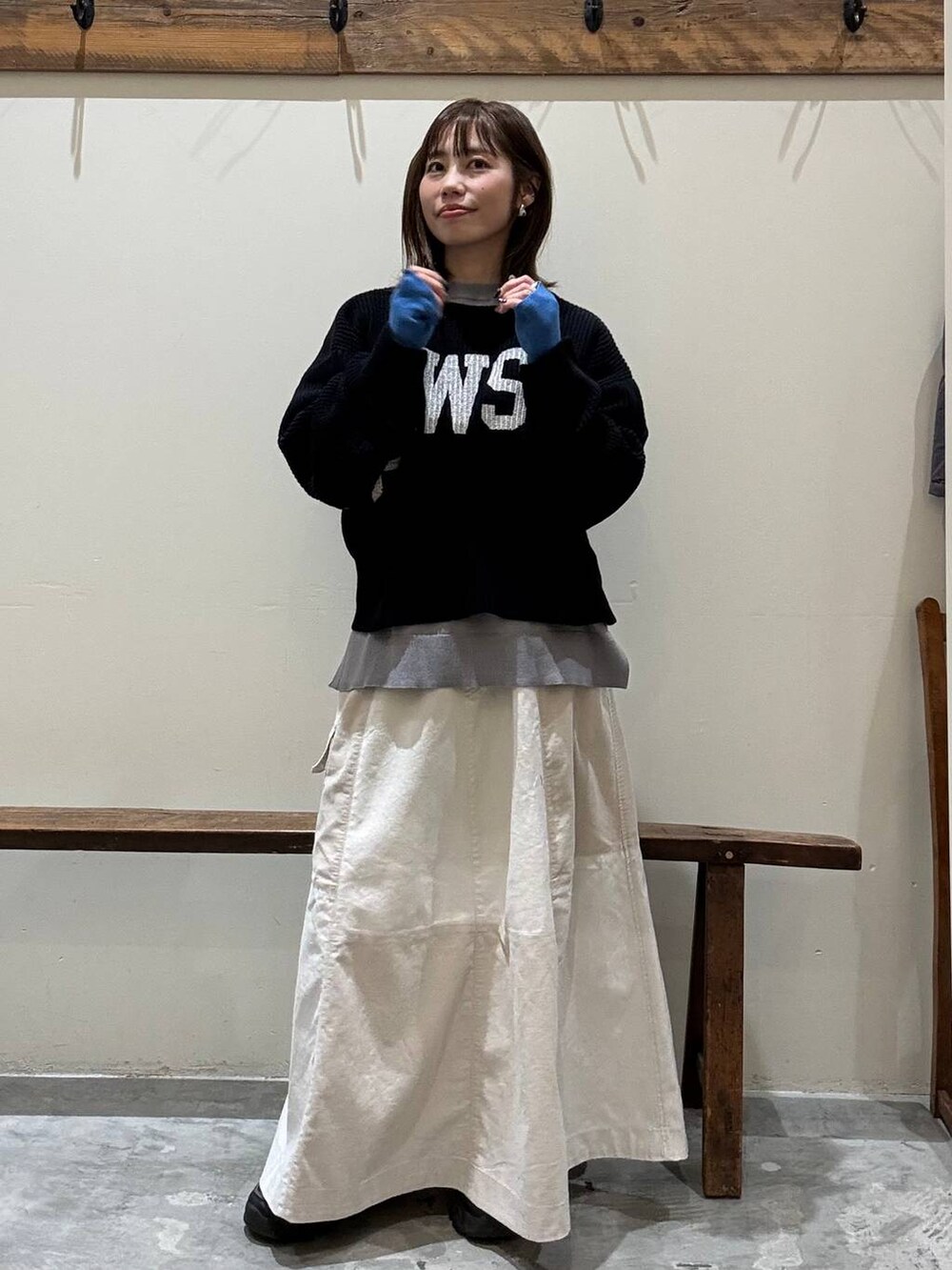 ベージュ系のスカート、ブルー系のニット/セーター、グレー系のニット/セーターを着用したレディースの冬コーディネートの2枚目の写真