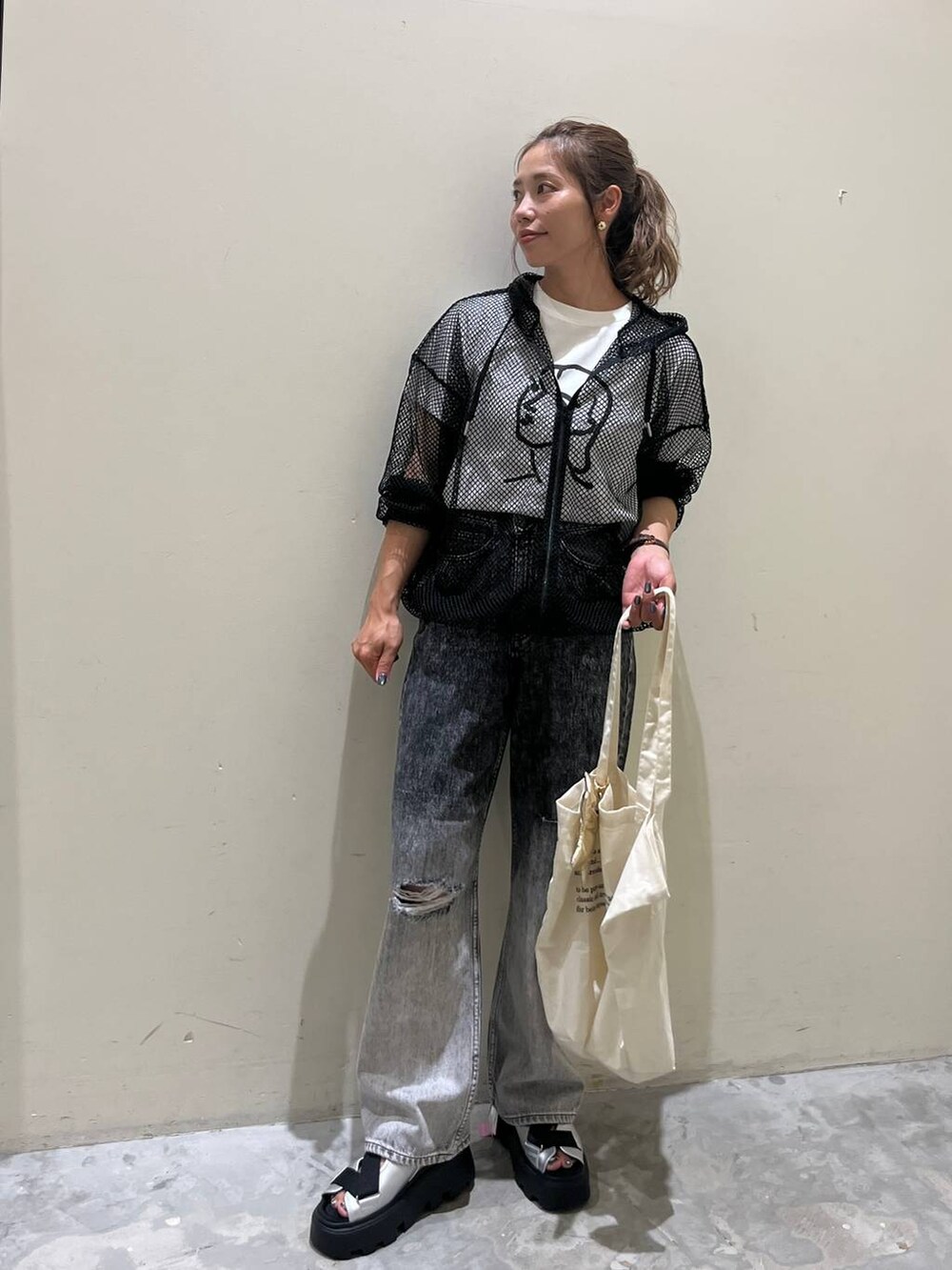グレー系のサンダル、ホワイト系のTシャツ/カットソー、ブラック系のデニムパンツを着用したレディースの夏コーディネートの2枚目の写真