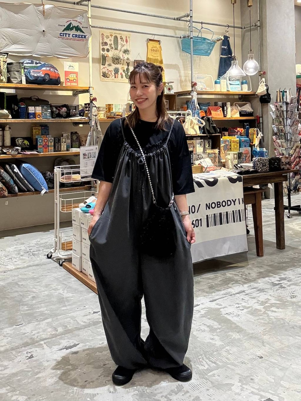 ブラック系のTシャツ/カットソー、グレー系のサロペット/オーバーオール、ブラック系のショルダーバッグを着用したレディースの夏コーディネートの6枚目の写真