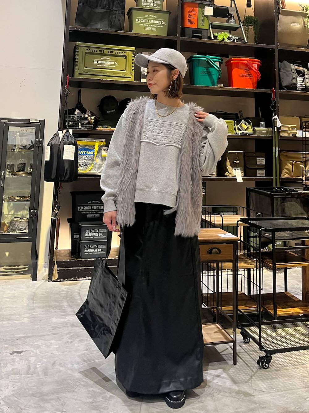 ブラック系のスカート、グレー系のその他トップス、ブラック系のトートバッグを着用したレディースの冬コーディネートの7枚目の写真