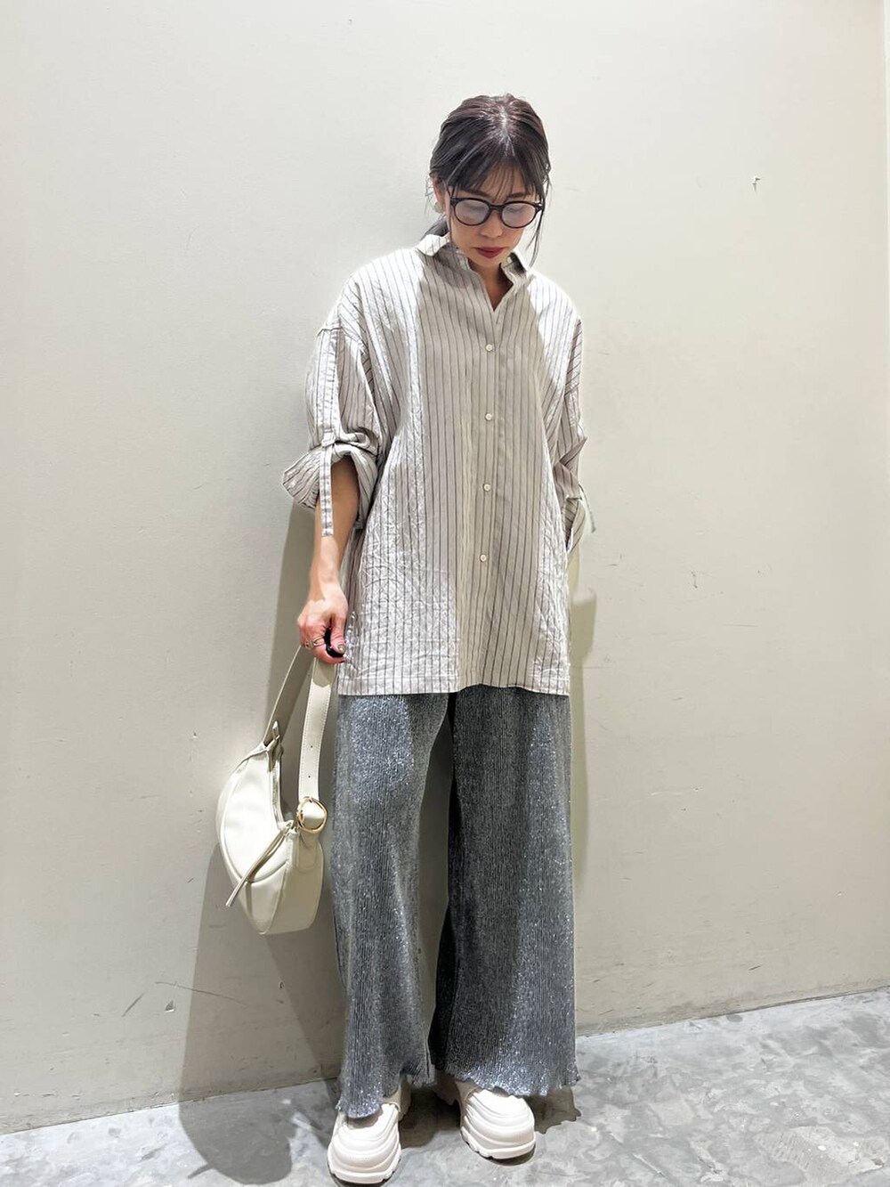 ベージュ系のショルダーバッグ、ベージュ系のローファー、グレー系のその他パンツを着用したレディースの春コーディネートの7枚目の写真