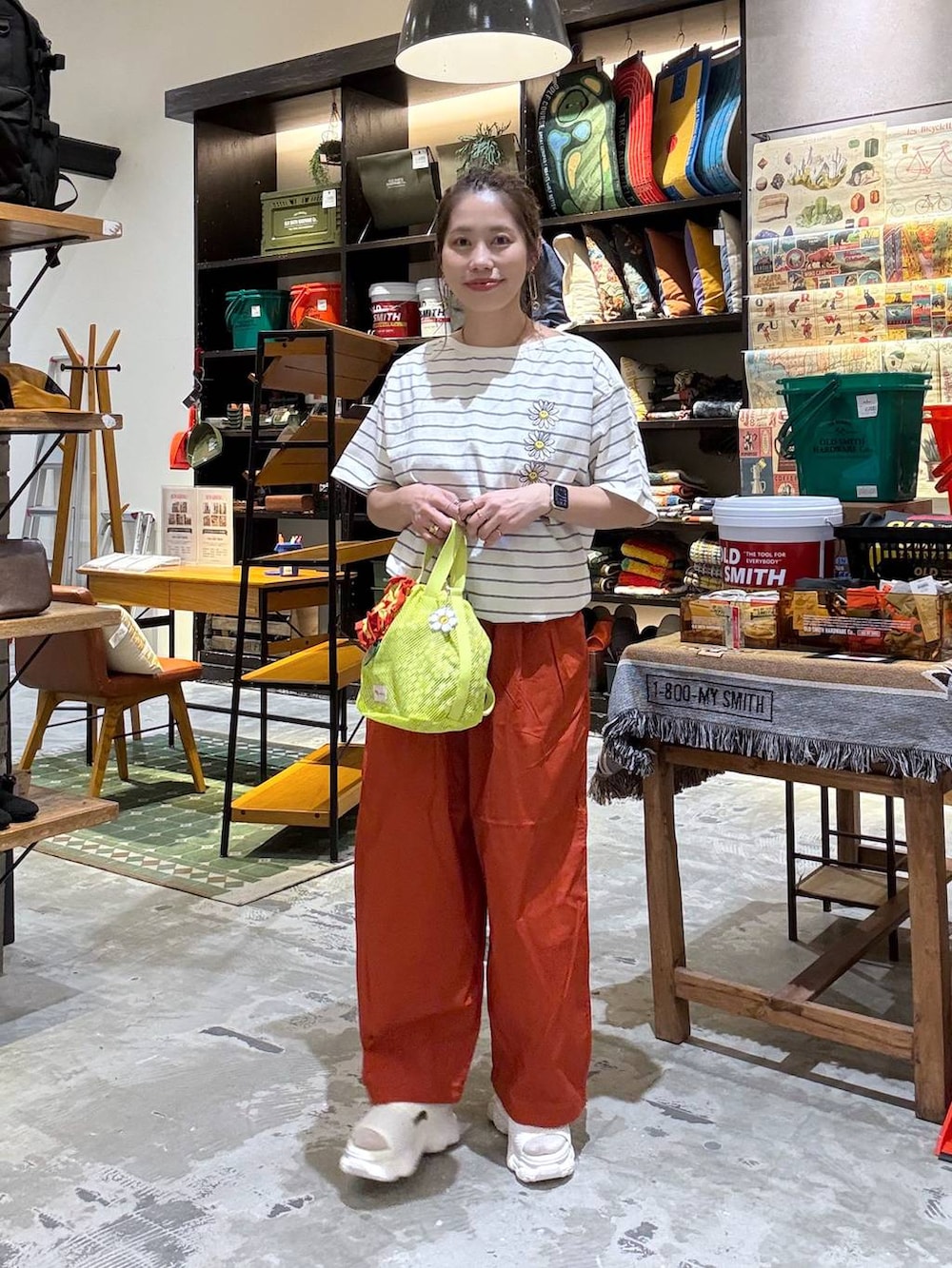 オレンジ系のその他パンツ、オレンジ系のTシャツ/カットソー、イエロー系のショルダーバッグを着用したレディースの春コーディネートの4枚目の写真