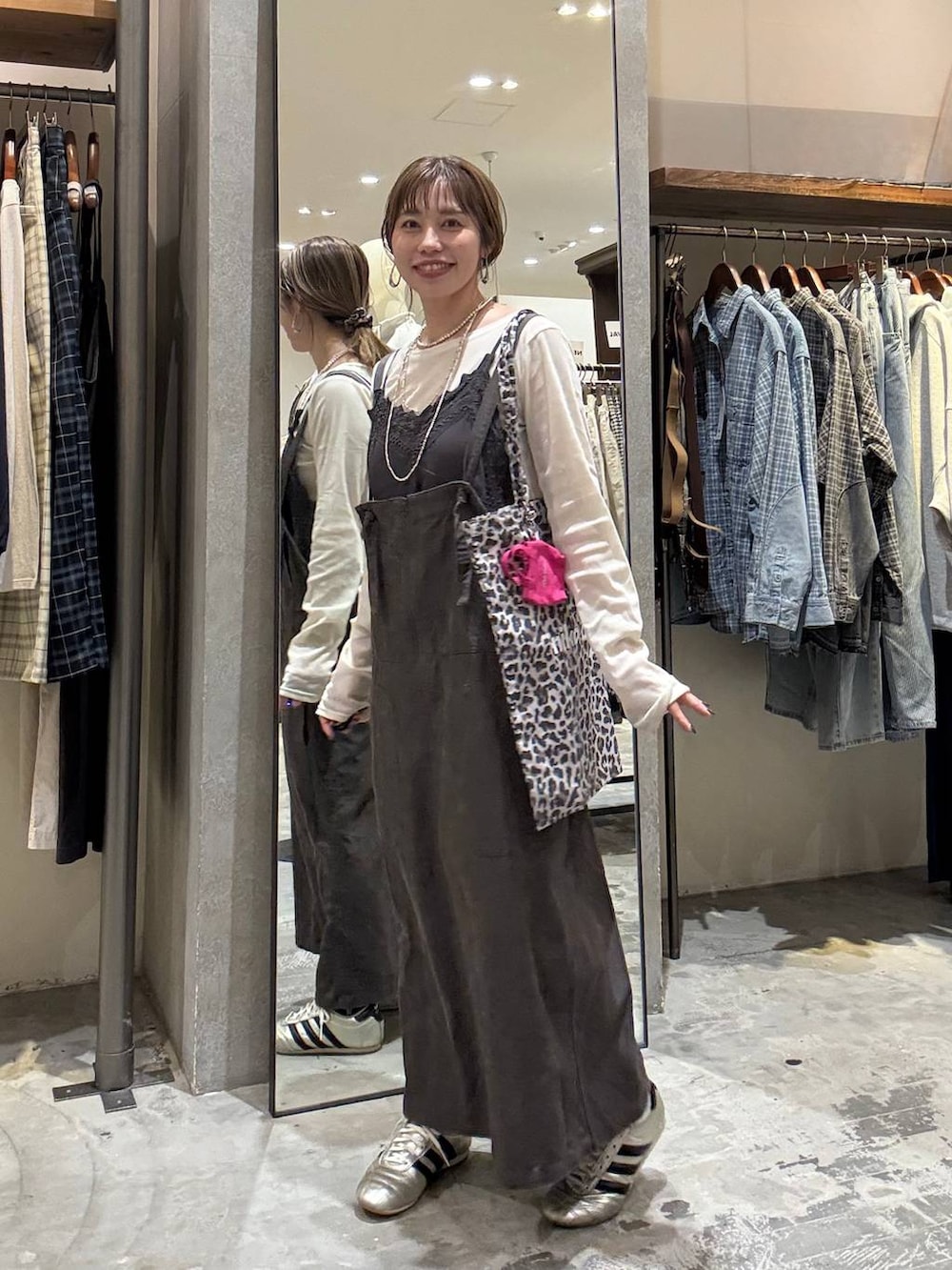 その他のトートバッグ、ゴールド系のスニーカー、グレー系のワンピースを着用したレディースの春コーディネートの4枚目の写真