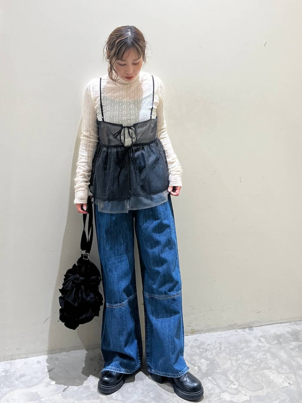 ブラック系のキャミソール、ブラック系のショルダーバッグ、ブラック系のブーツを着用したレディースの冬コーディネートの2枚目の写真