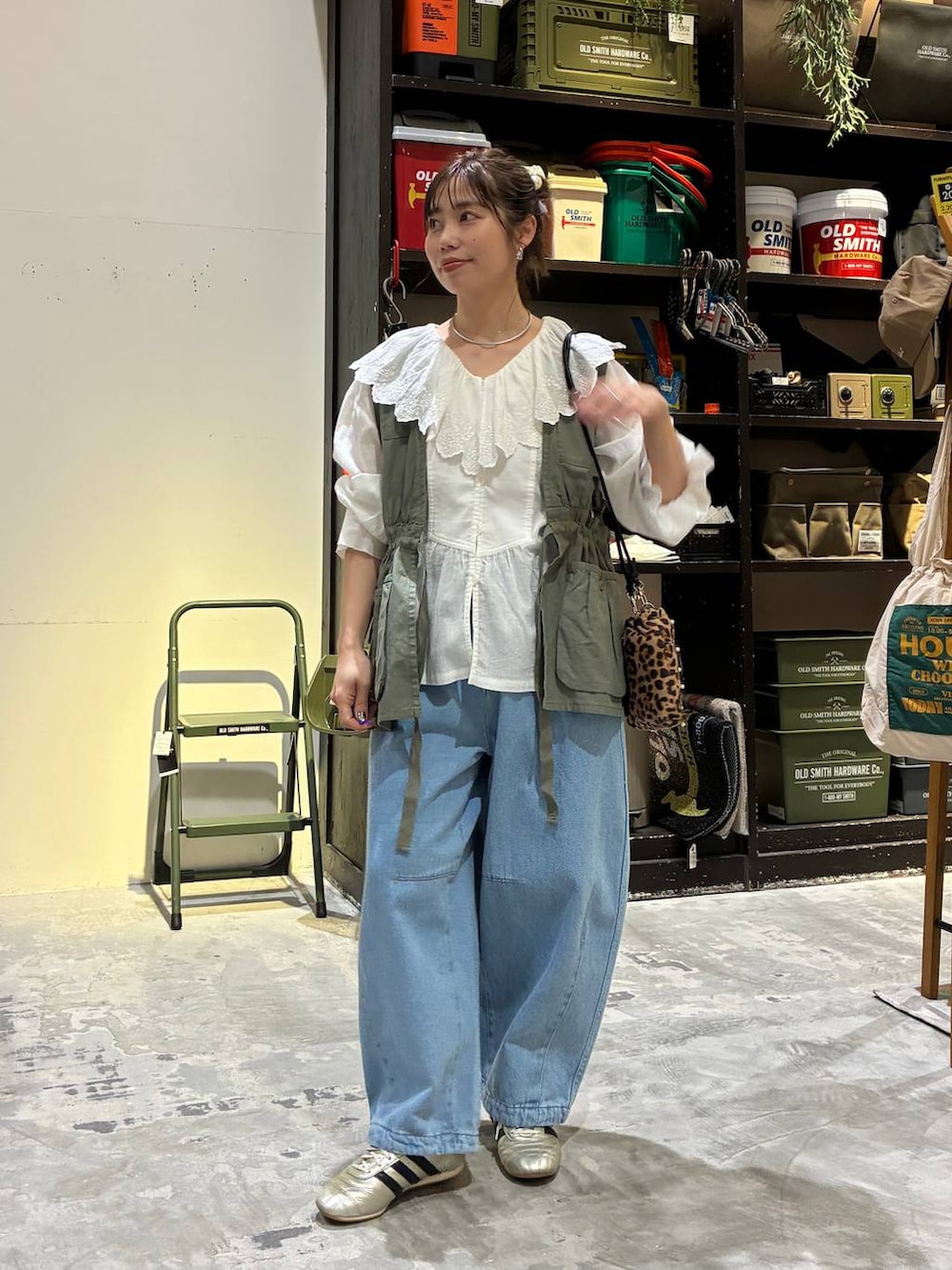 その他のショルダーバッグ、ゴールド系のスニーカー、グリーン系のベストを着用したレディースの冬コーディネートの5枚目の写真