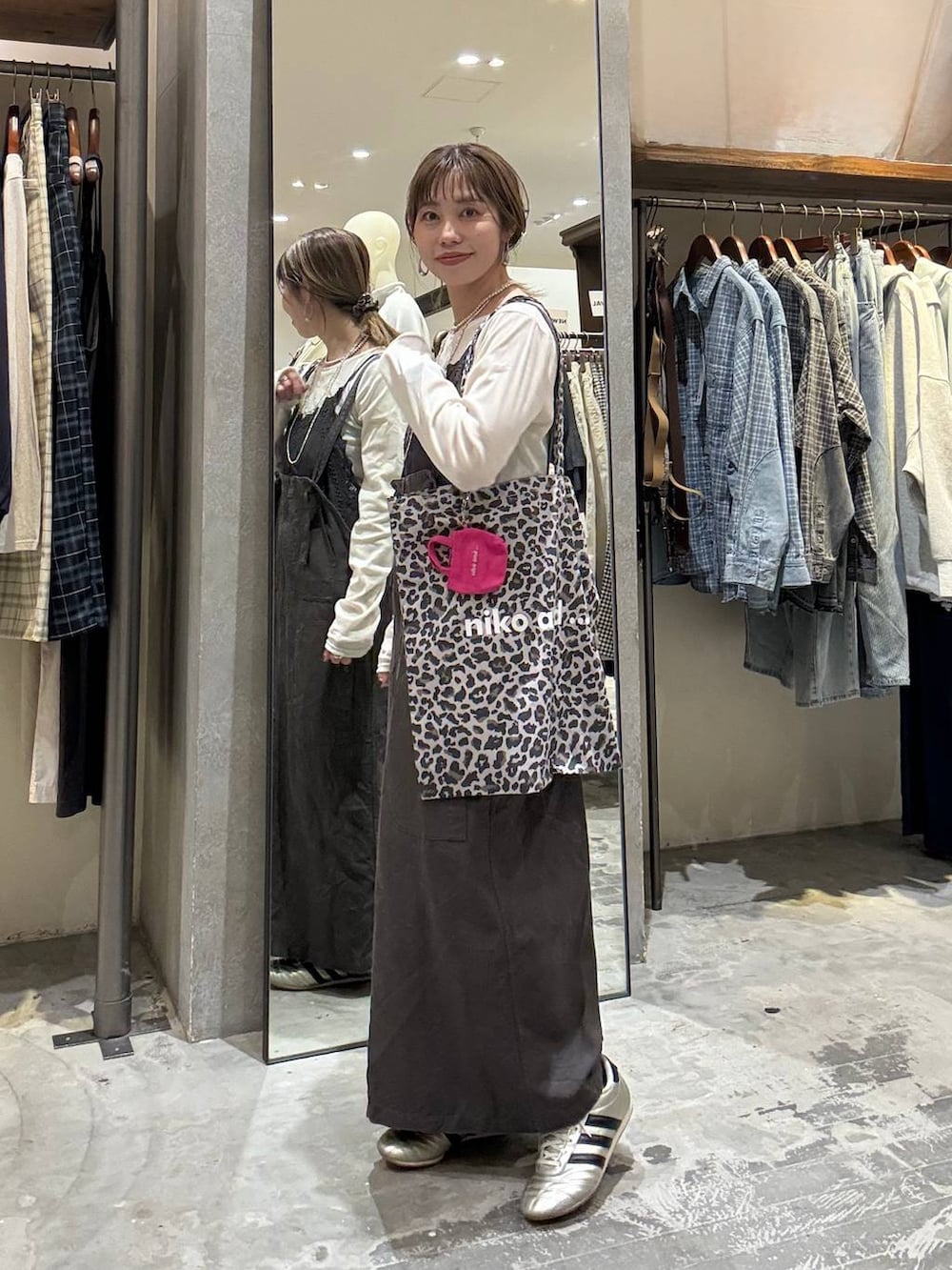 その他のトートバッグ、ゴールド系のスニーカー、グレー系のワンピースを着用したレディースの春コーディネートの6枚目の写真