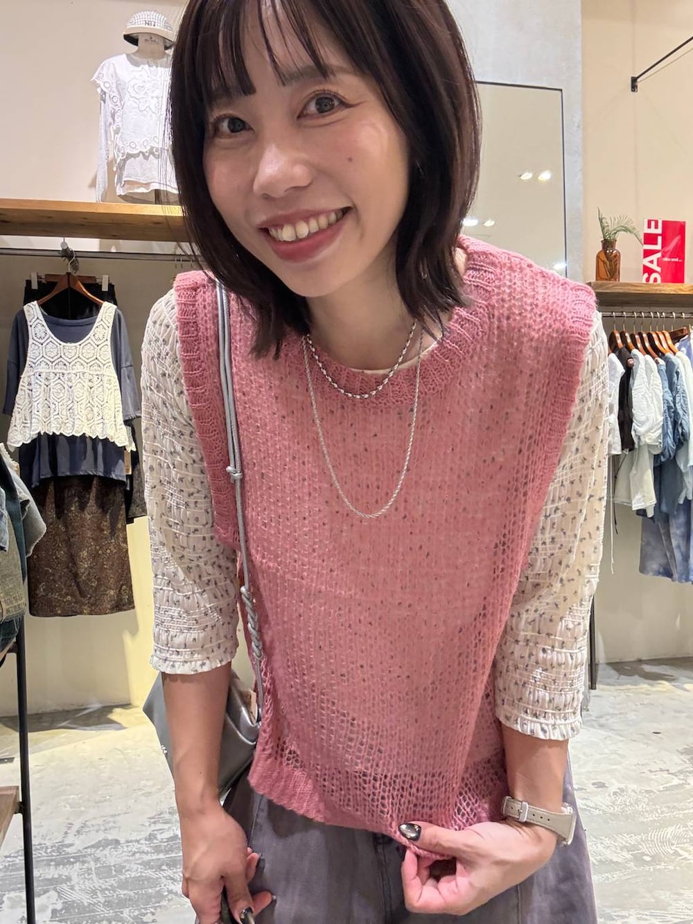 ピンク系のベスト、ベージュ系のTシャツ/カットソー、パープル系のデニムパンツを着用したレディースの夏コーディネートの2枚目の写真