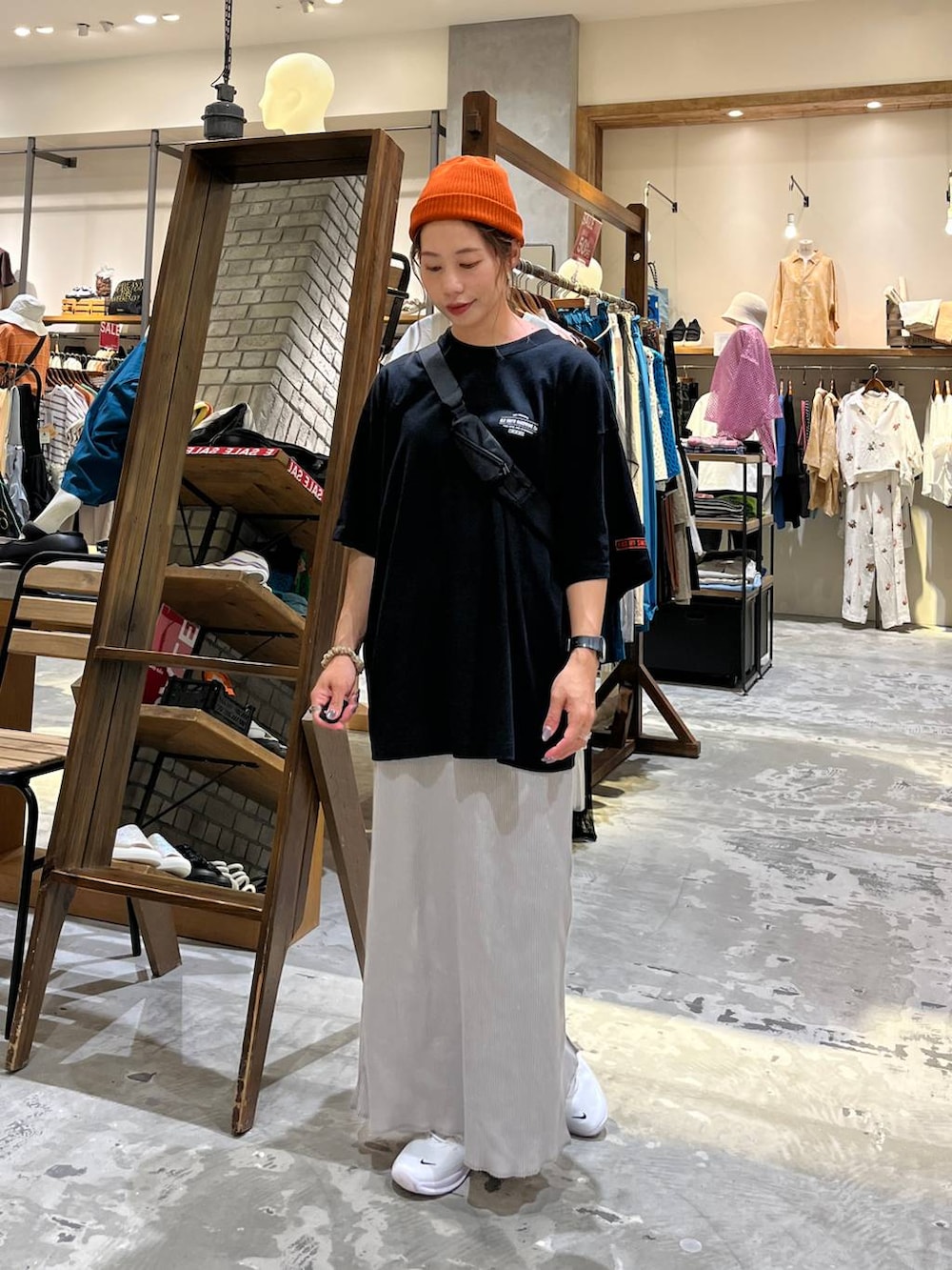 ブラック系のショルダーバッグ、グレー系のスカート、ブラック系のTシャツ/カットソーを着用したレディースの夏コーディネートの3枚目の写真