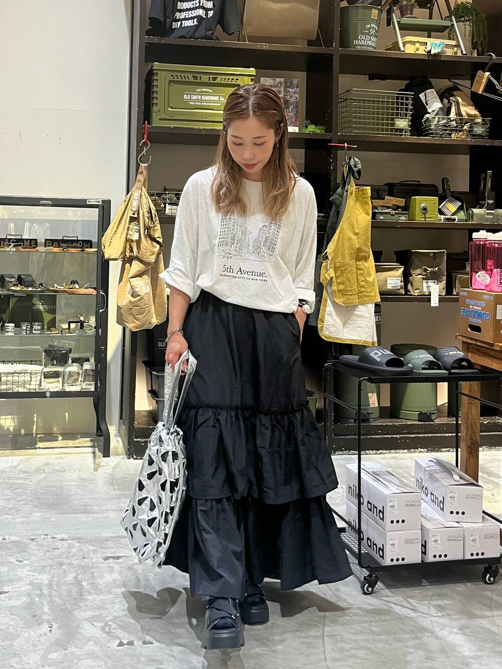 ベージュ系のTシャツ/カットソー、その他のトートバッグ、ブラック系のスカートを着用したレディースの夏コーディネートの5枚目の写真