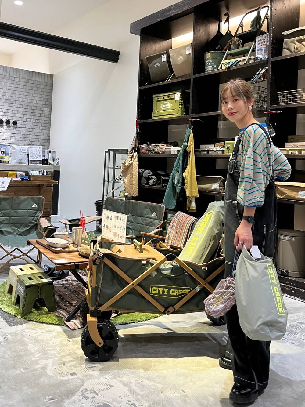 グレー系のハンドバッグ、ブラック系のローファー、ベージュ系のTシャツ/カットソーを着用したレディースの春コーディネートの2枚目の写真