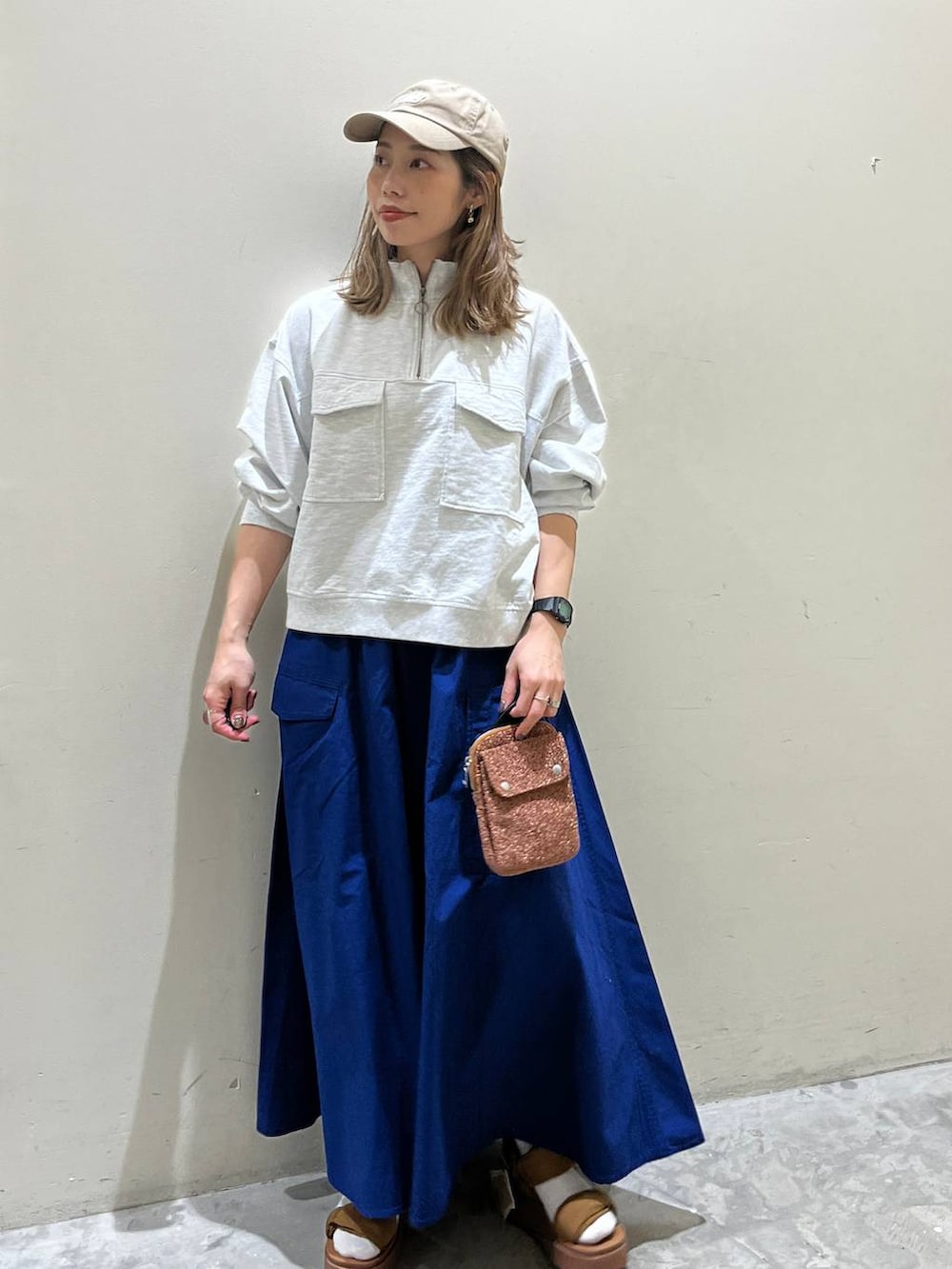 イエロー系のサンダル、ベージュ系のスウェット、オレンジ系のショルダーバッグを着用したレディースの春コーディネートの4枚目の写真