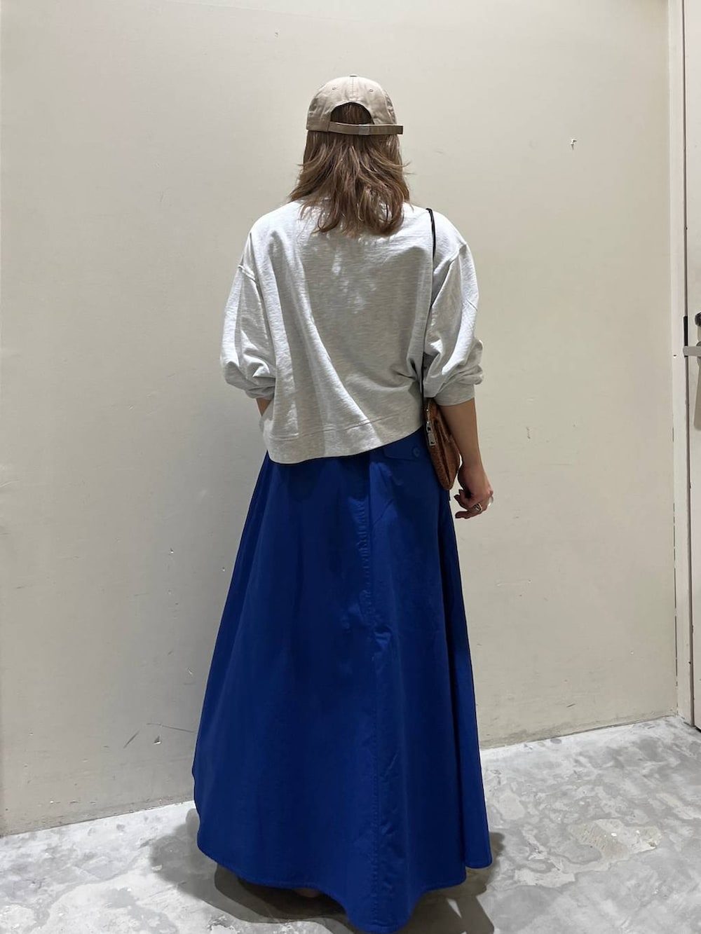 イエロー系のサンダル、ベージュ系のスウェット、オレンジ系のショルダーバッグを着用したレディースの春コーディネートの3枚目の写真