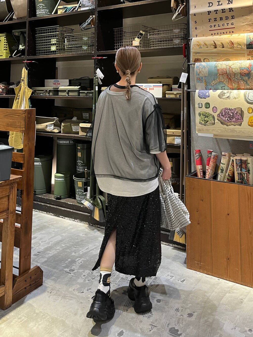 ブラック系のスニーカー、ブラック系のスカート、ベージュ系のTシャツ/カットソーを着用したレディースの春コーディネートの3枚目の写真