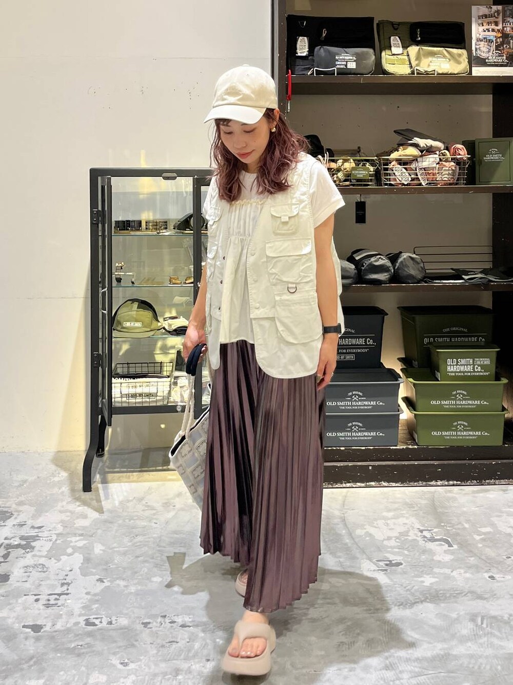 ベージュ系のサンダル、ベージュ系のスカート、ベージュ系のベストを着用したレディースの夏コーディネートの2枚目の写真