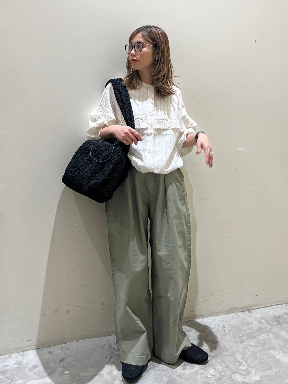 ブラック系のショルダーバッグ、ブラック系のその他シューズ、ベージュ系のシャツ/ブラウスを着用したレディースの春コーディネートの4枚目の写真