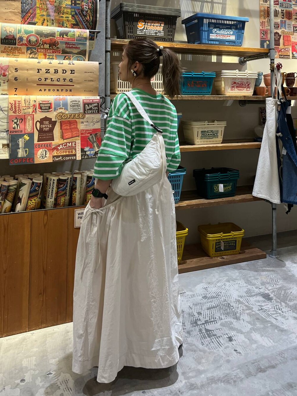 ベージュ系のスカート、ホワイト系のショルダーバッグ、グリーン系のTシャツ/カットソーを着用したレディースの春コーディネートの4枚目の写真