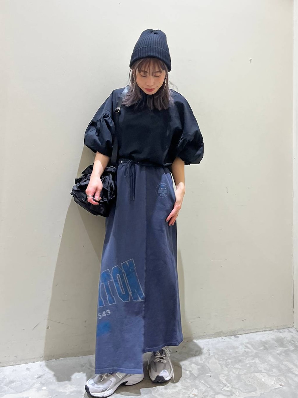 ブラック系のショルダーバッグ、ブルー系のスカート、ブラック系のシャツ/ブラウスを着用したレディースの春コーディネートの3枚目の写真