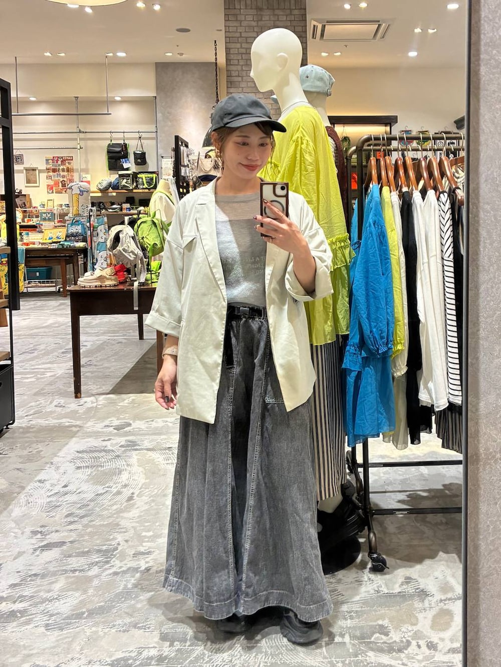 グレー系のスカート、ベージュ系のテーラードジャケット、グレー系のTシャツ/カットソーを着用したレディースの春コーディネートの3枚目の写真