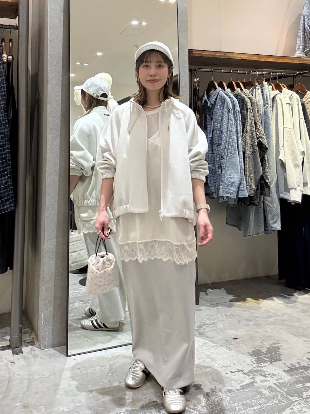 ゴールド系のスニーカー、ホワイト系のショルダーバッグ、ベージュ系のブルゾンを着用したレディースの春コーディネートの5枚目の写真