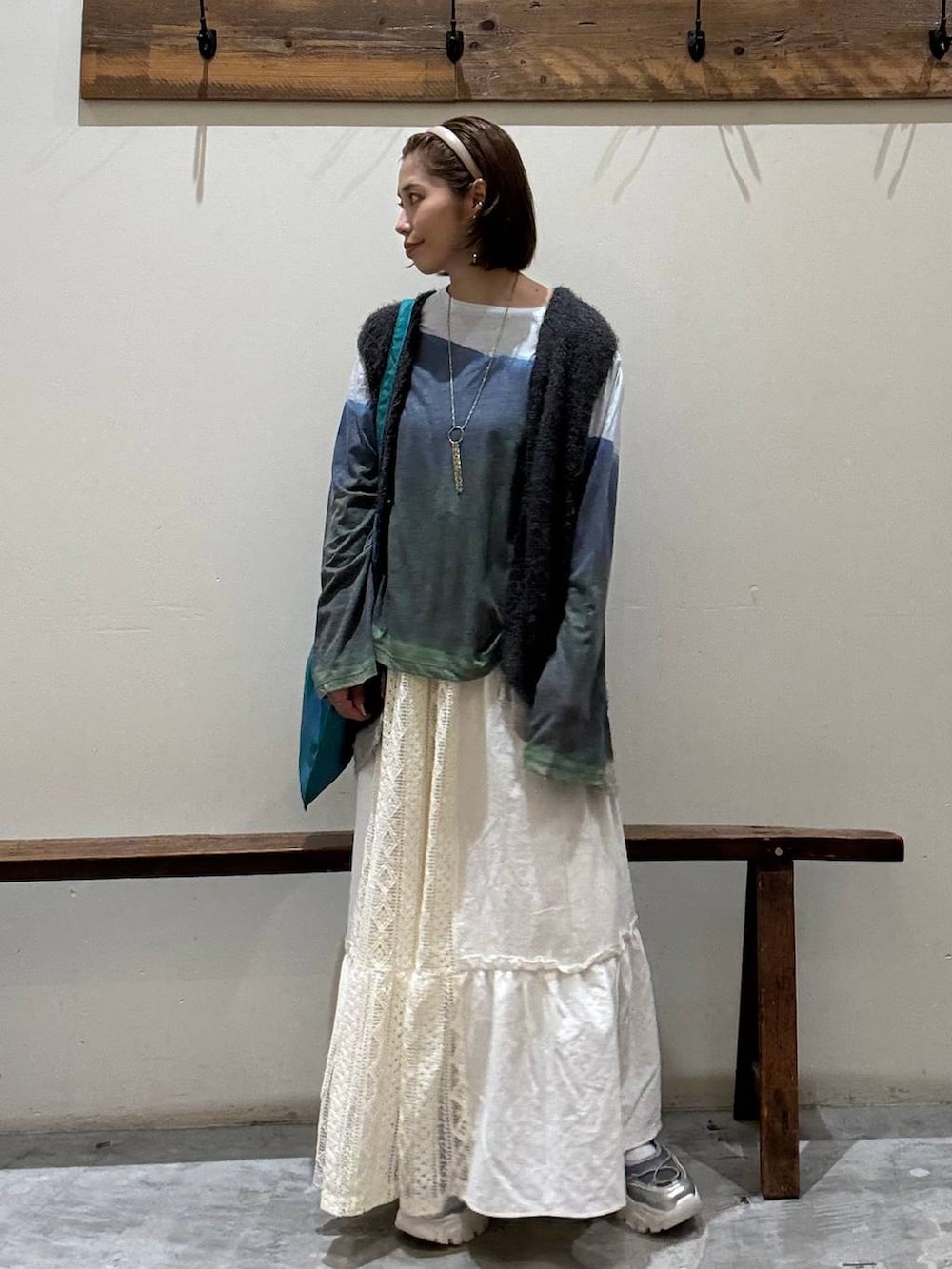 シルバー系のスニーカー、その他のトートバッグ、ベージュ系のスカートを着用したレディースの秋コーディネートの6枚目の写真