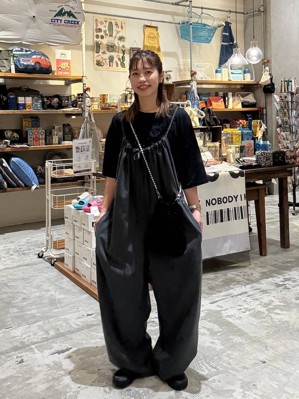 ブラック系のTシャツ/カットソー、グレー系のサロペット/オーバーオール、ブラック系のショルダーバッグを着用したレディースの夏コーディネートの2枚目の写真