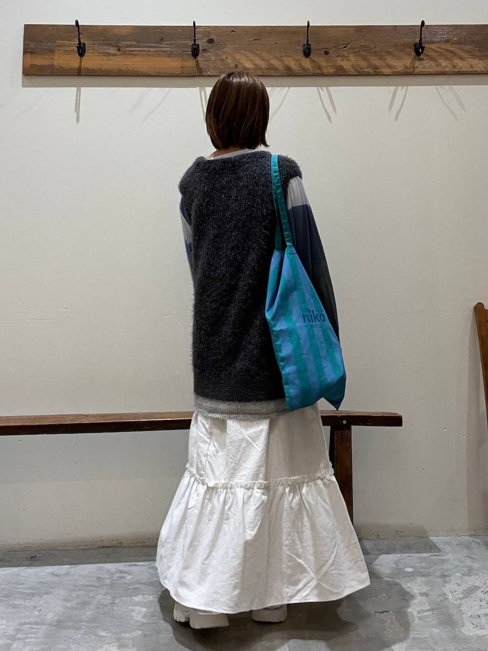 シルバー系のスニーカー、その他のトートバッグ、ベージュ系のスカートを着用したレディースの秋コーディネートの5枚目の写真