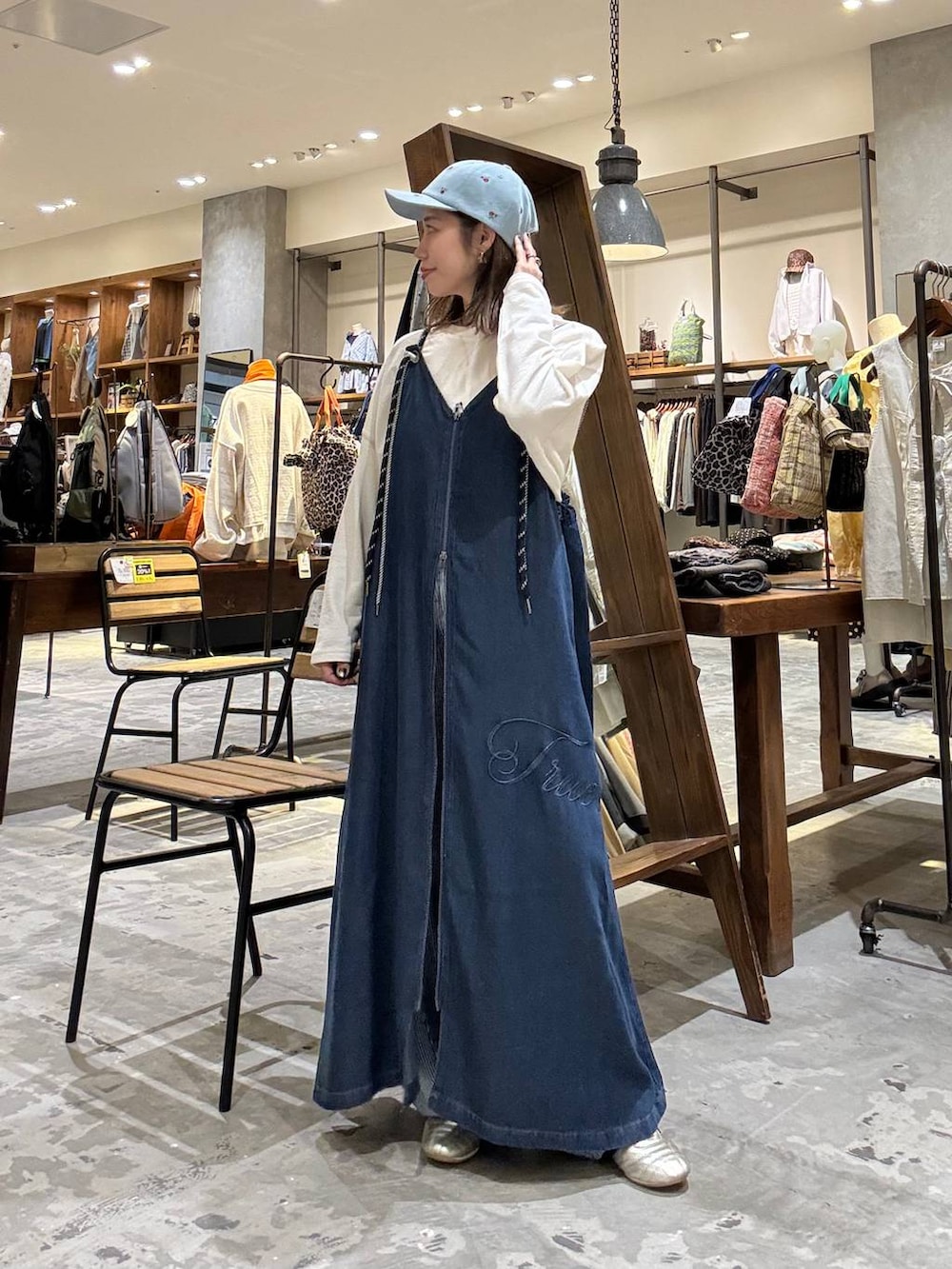 ゴールド系のスニーカー、ブルー系のデニムパンツ、ホワイト系のTシャツ/カットソーを着用したレディースの冬コーディネートの2枚目の写真