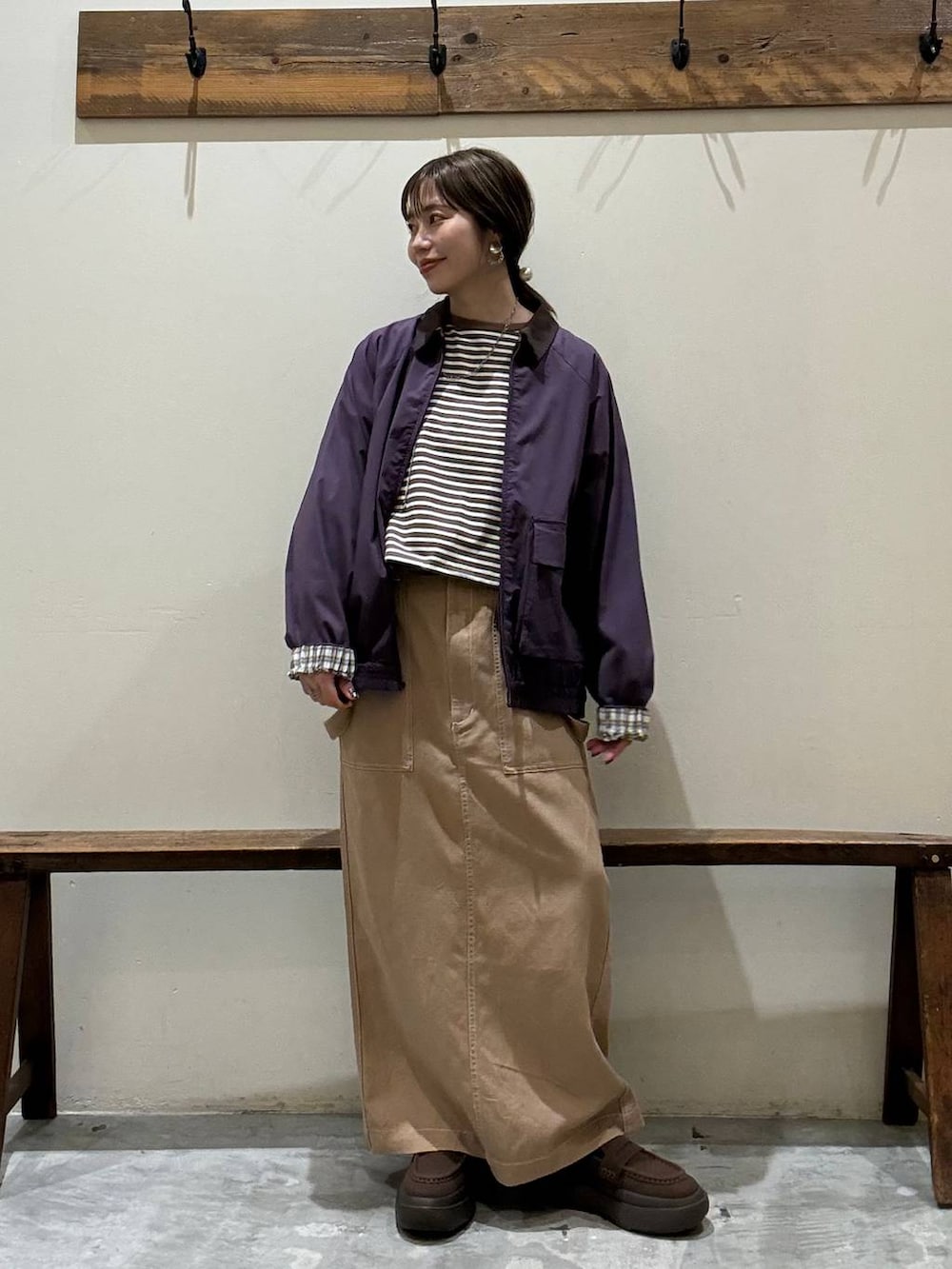 イエロー系のスカート、レッド系のブルゾン、ブラウン系のローファーを着用したレディースの春コーディネートの6枚目の写真