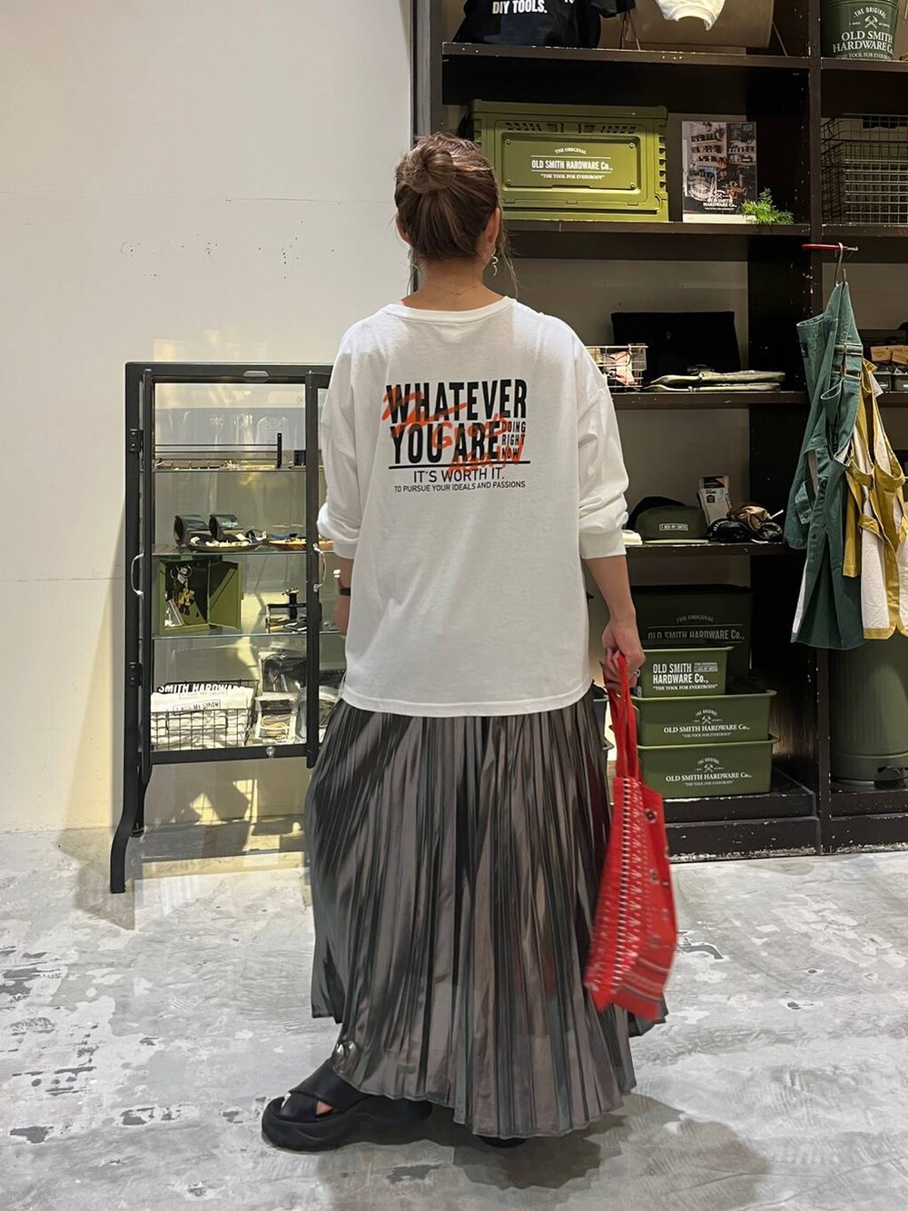 ブラック系のサンダル、ホワイト系のTシャツ/カットソー、レッド系のトートバッグを着用したレディースの夏コーディネートの2枚目の写真