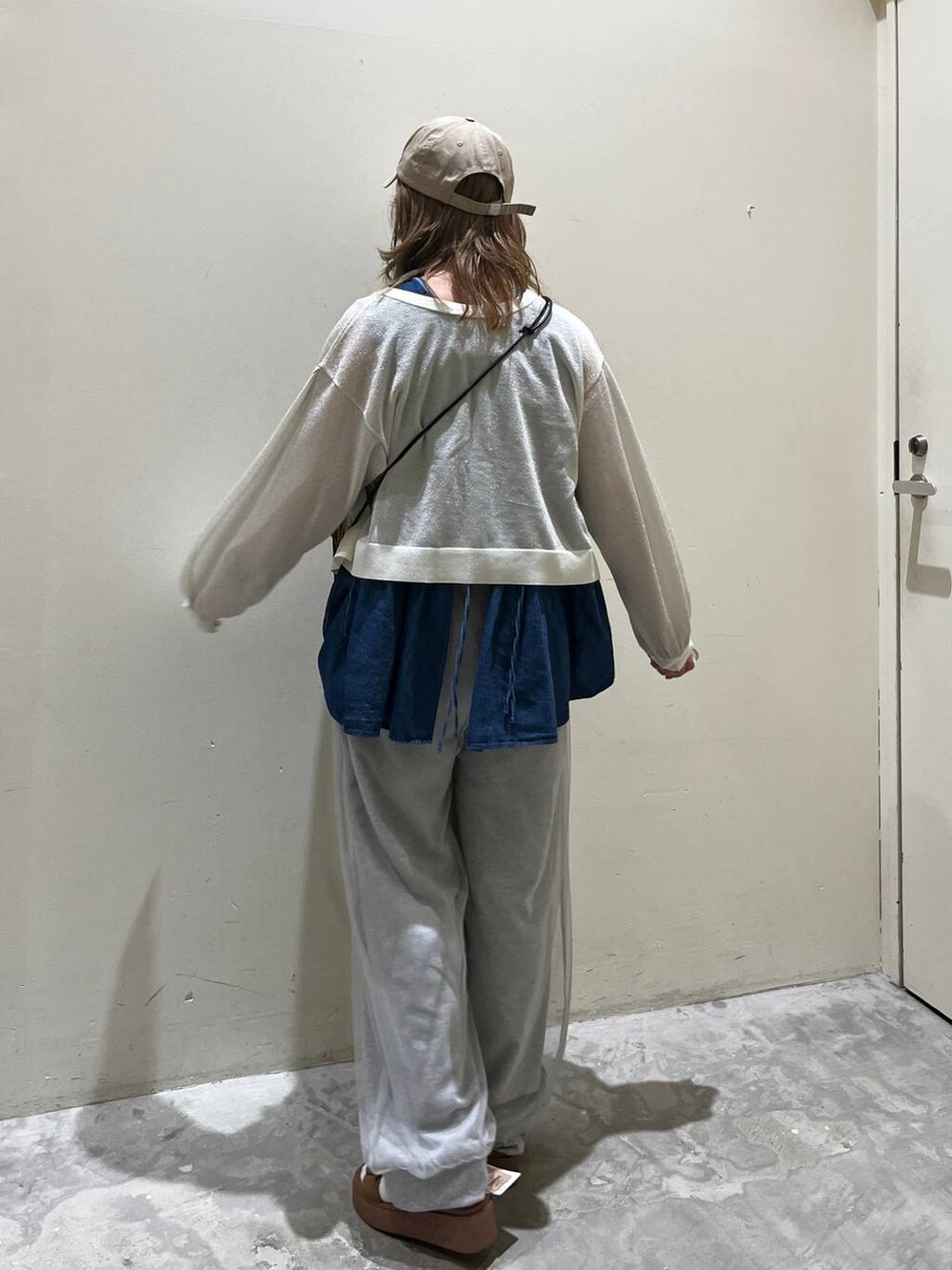 イエロー系のサンダル、ブルー系のベスト、オレンジ系のショルダーバッグを着用したレディースの春コーディネートの4枚目の写真