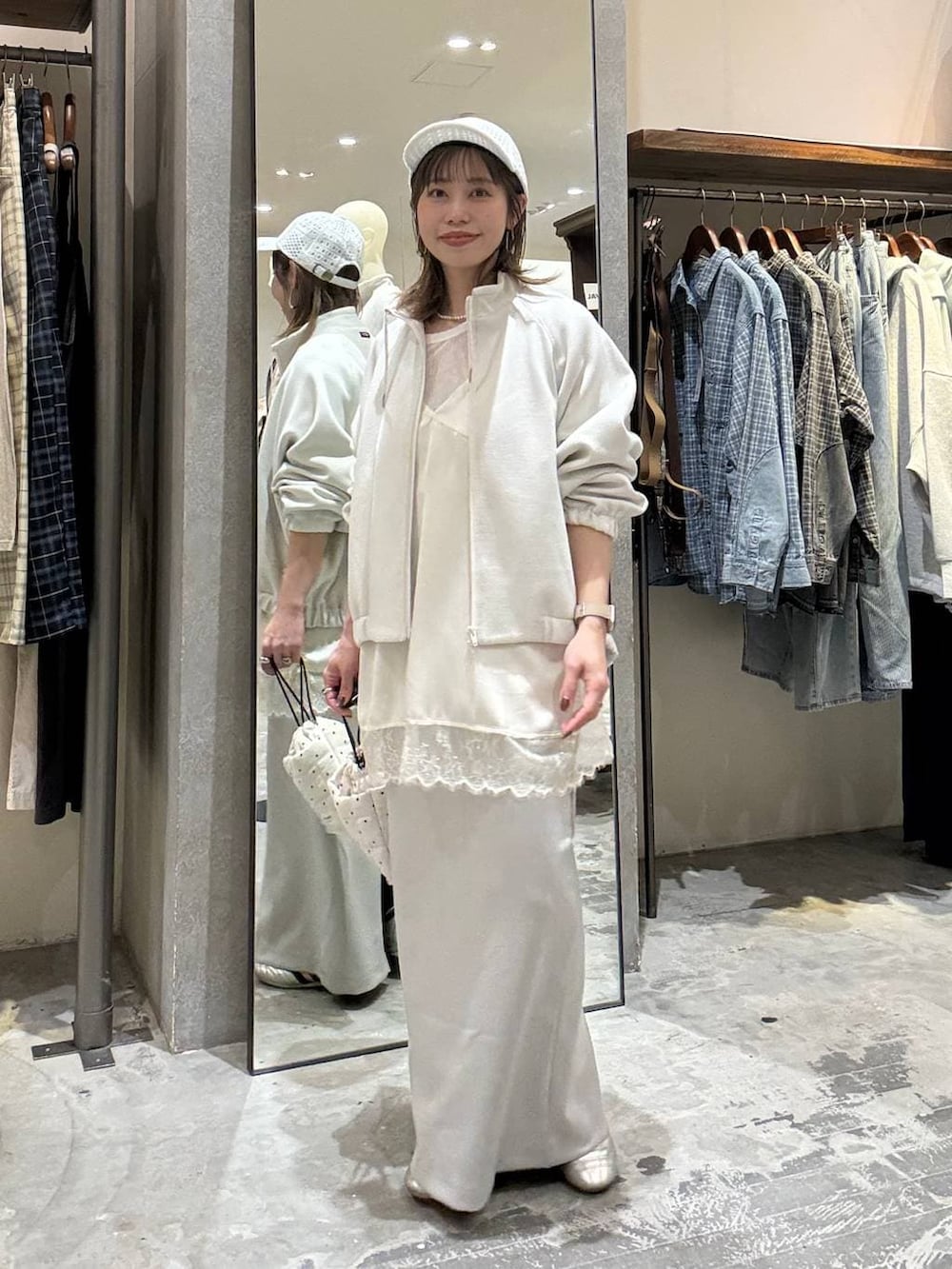 ゴールド系のスニーカー、ホワイト系のショルダーバッグ、ベージュ系のブルゾンを着用したレディースの春コーディネートの3枚目の写真