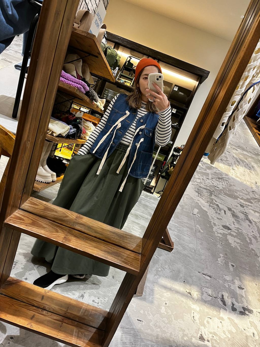 ホワイト系のニット/セーター、グリーン系のスカート、ブルー系のベストを着用したレディースの冬コーディネートの3枚目の写真