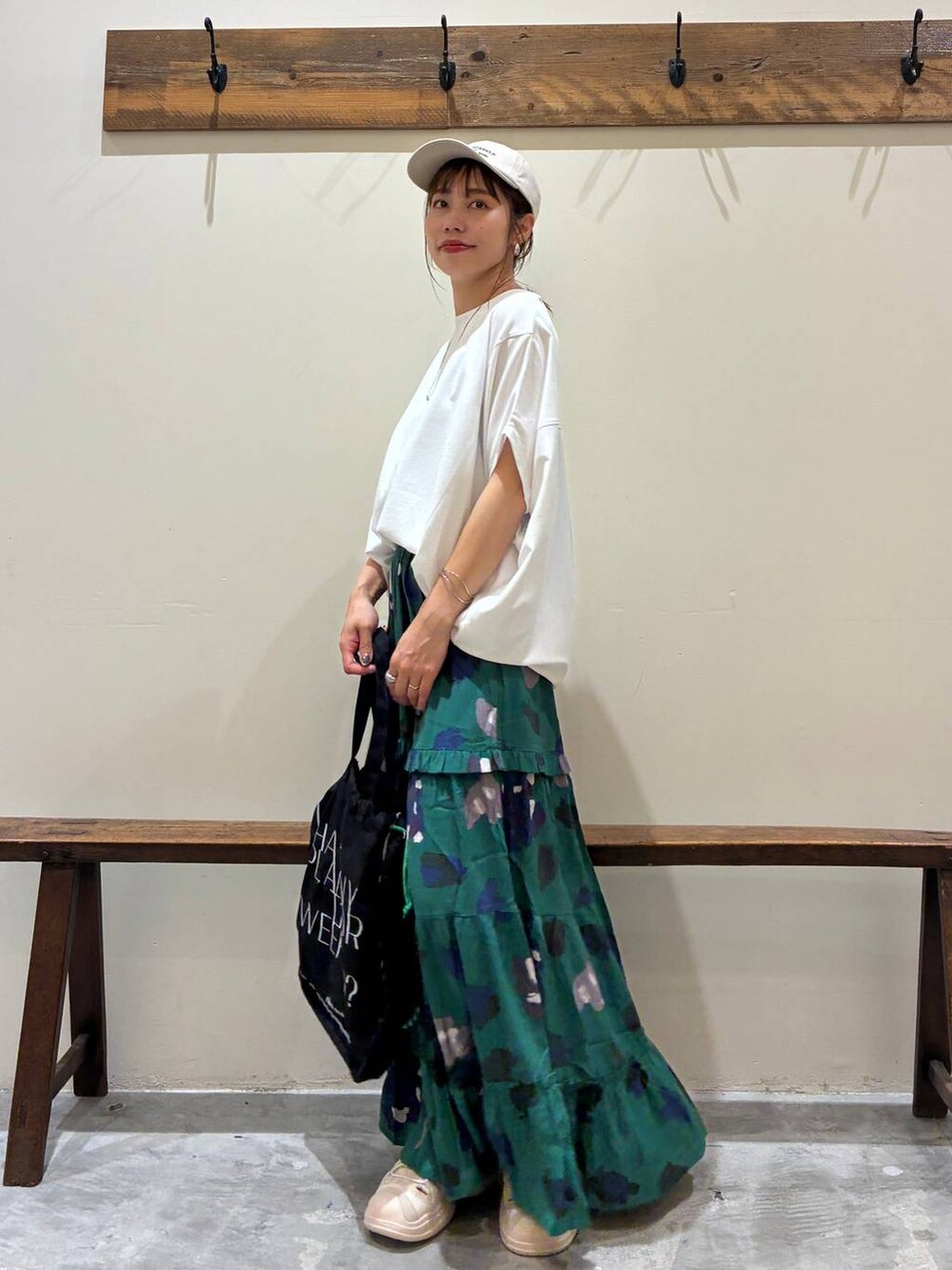 ブラック系のトートバッグ、グリーン系のスカート、ベージュ系のサンダルを着用したレディースの夏コーディネートの10枚目の写真