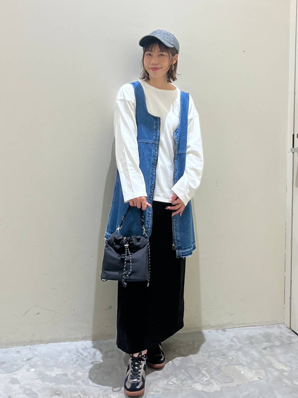 ブラック系のスカート、ブルー系のドレス、シルバー系のスニーカーを着用したレディースの冬コーディネートの7枚目の写真