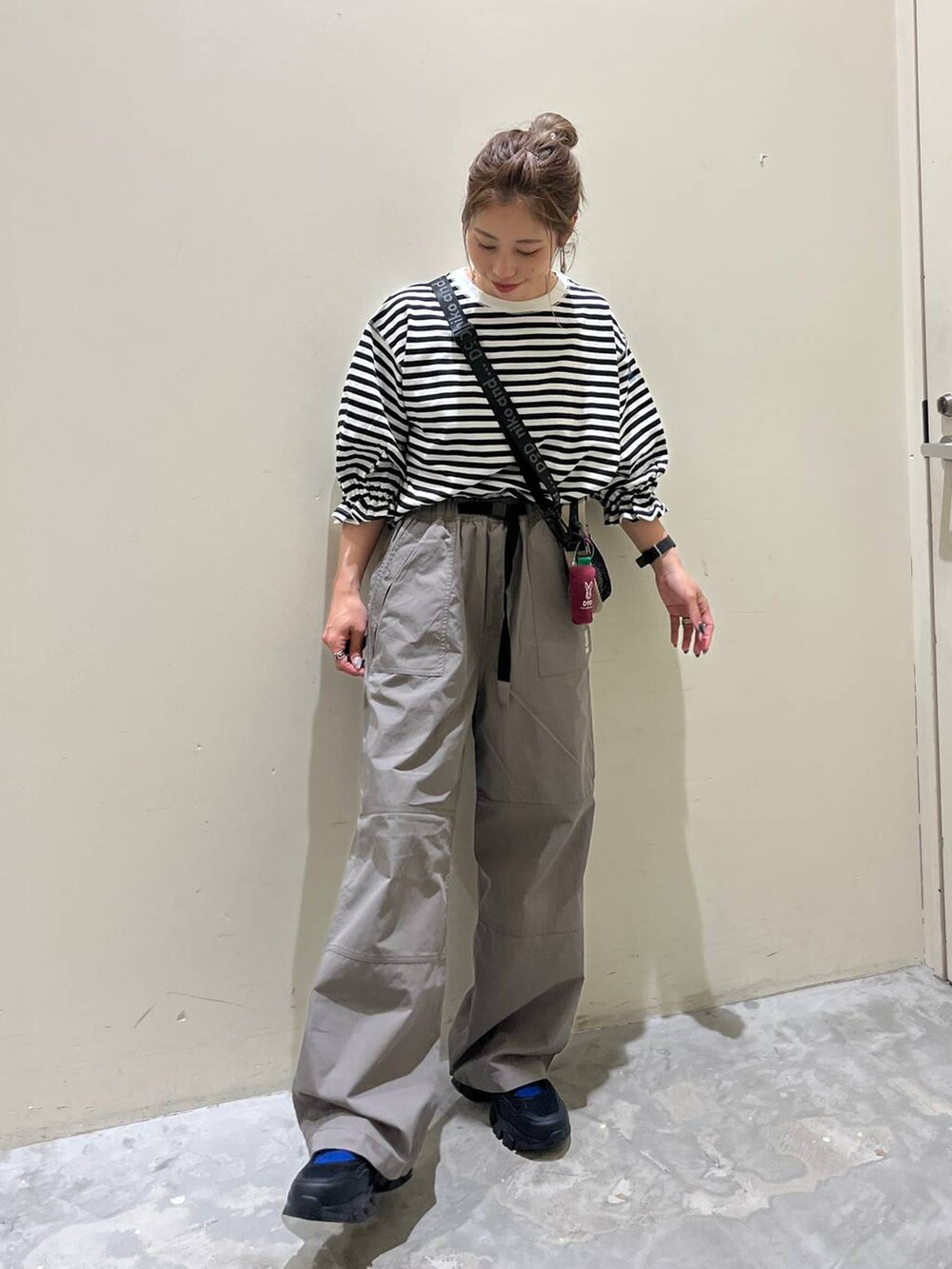 グレー系のその他パンツ、ブラック系のスニーカー、ホワイト系のTシャツ/カットソーを着用したレディースの春コーディネートの2枚目の写真