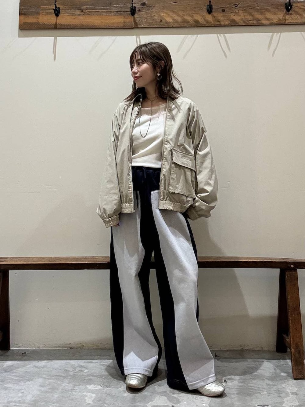 ゴールド系のスニーカー、ブルー系のデニムパンツ、イエロー系のブルゾンを着用したレディースの冬コーディネートの2枚目の写真