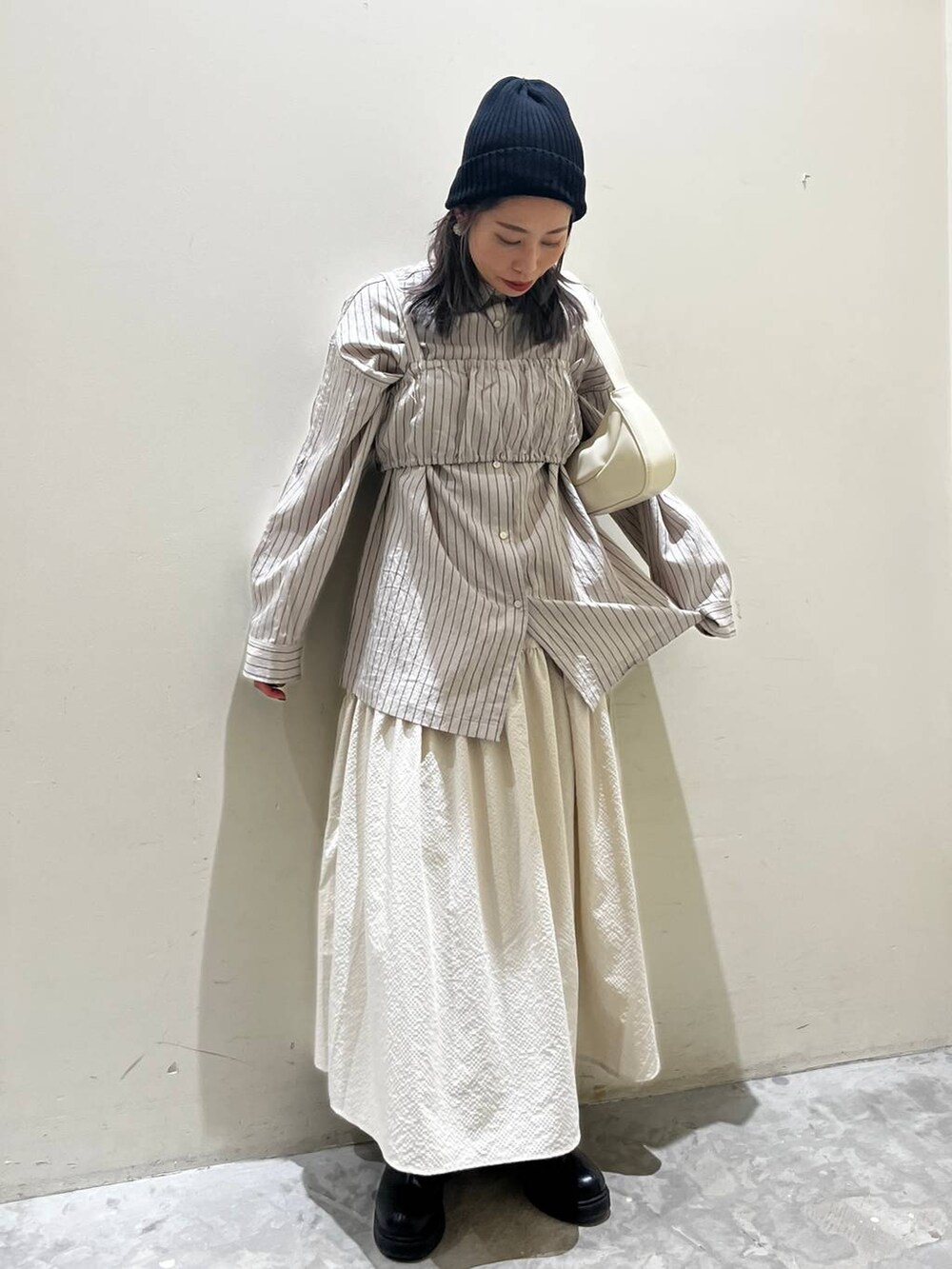 ベージュ系のショルダーバッグ、ブラック系のブーツ、ベージュ系のシャツ/ブラウスを着用したレディースの春コーディネートの4枚目の写真