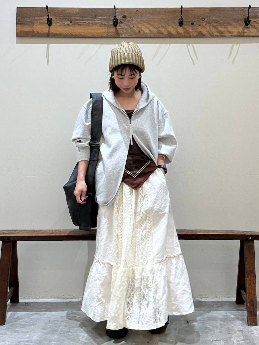 ベージュ系のスカート、ブラック系のショルダーバッグ、グレー系のパーカーを着用したレディースの秋コーディネートの6枚目の写真