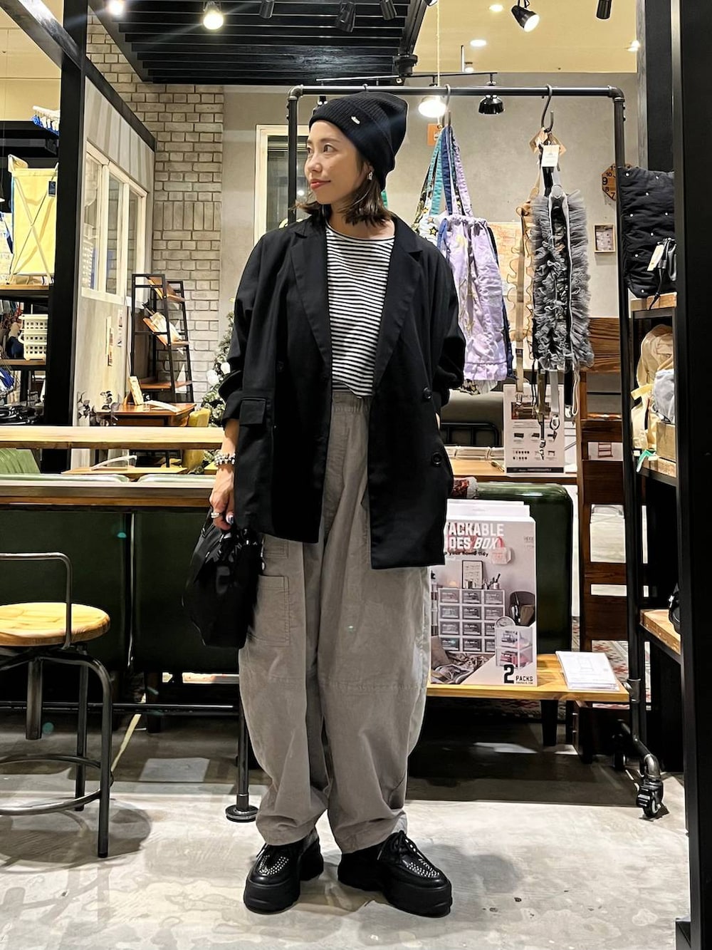 ブラック系のその他シューズ、ブラック系のショルダーバッグ、ブラック系のその他アウターを着用したレディースの秋コーディネートの4枚目の写真