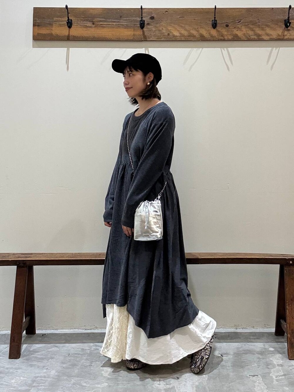 シルバー系のショルダーバッグ、グレー系のワンピース、ベージュ系のスカートを着用したレディースの秋コーディネートの7枚目の写真