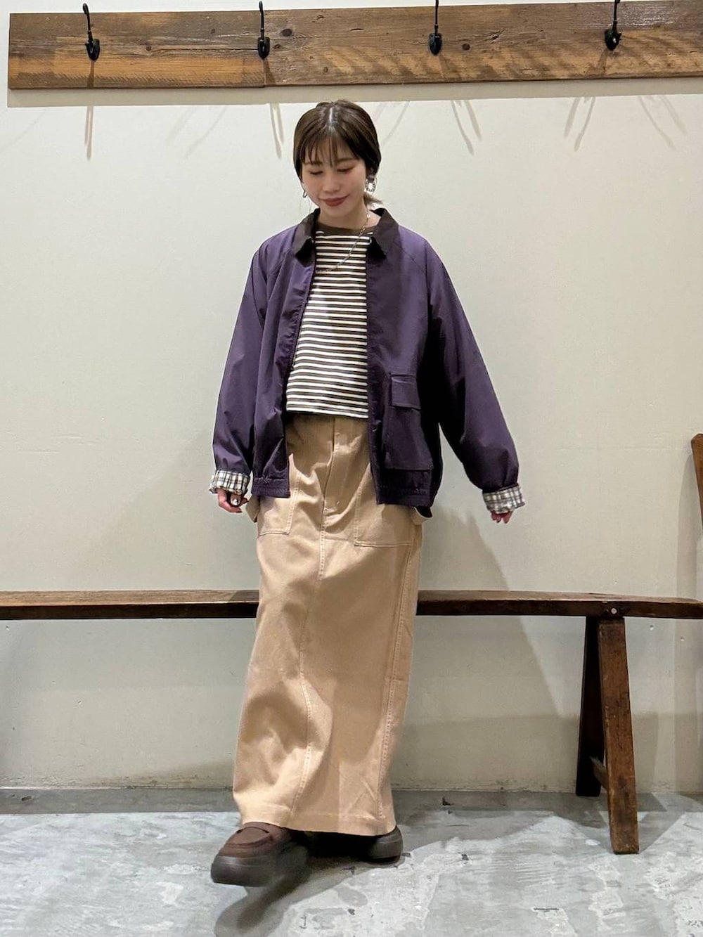 イエロー系のスカート、レッド系のブルゾン、ブラウン系のローファーを着用したレディースの春コーディネートの4枚目の写真