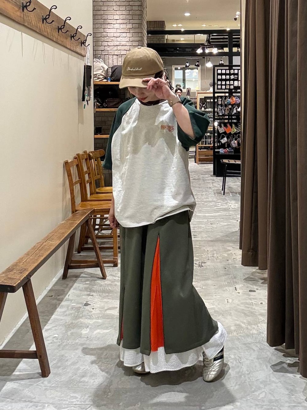 ゴールド系のスニーカー、ホワイト系のスカート、グリーン系のTシャツ/カットソーを着用したレディースの夏コーディネートの2枚目の写真