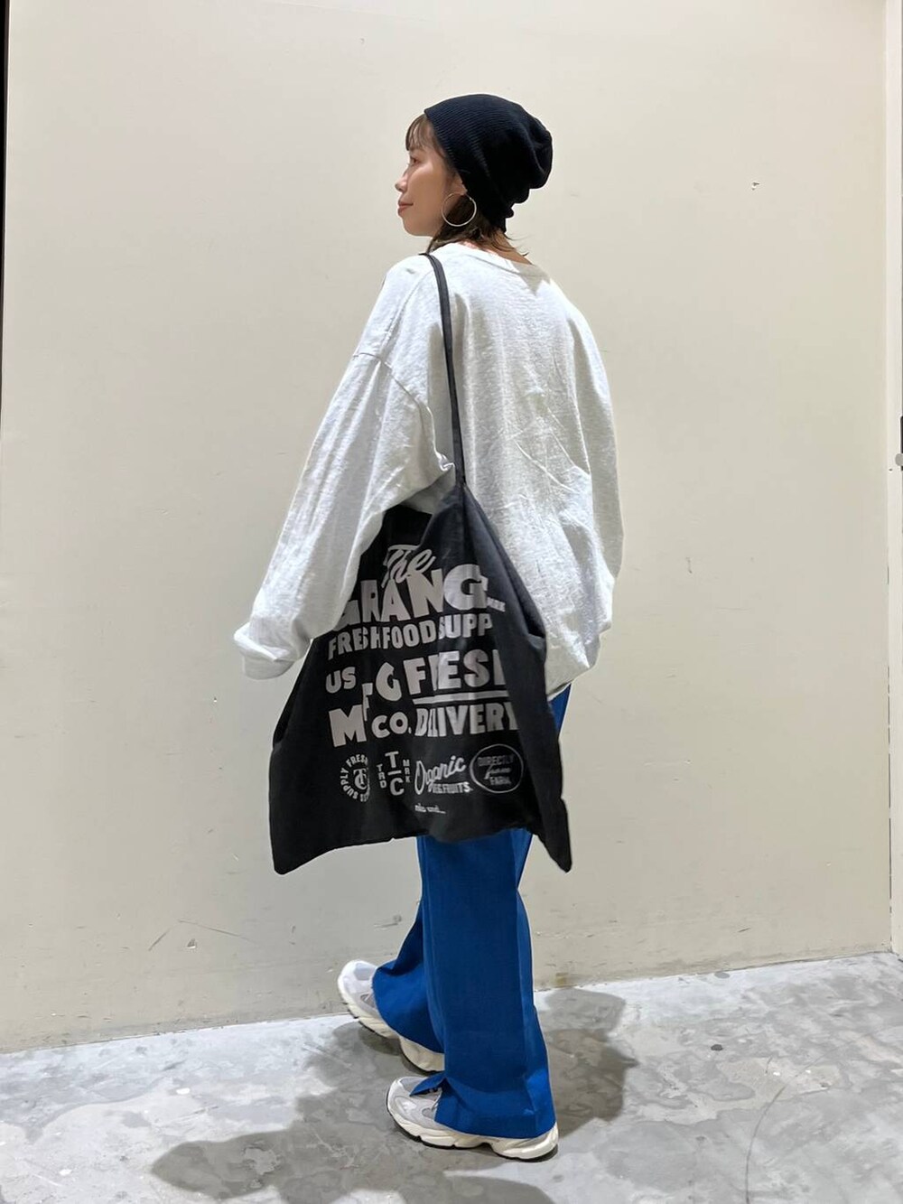 グレー系のトートバッグ、グレー系のTシャツ/カットソー、グレー系のスニーカーを着用したレディースの春コーディネートの2枚目の写真