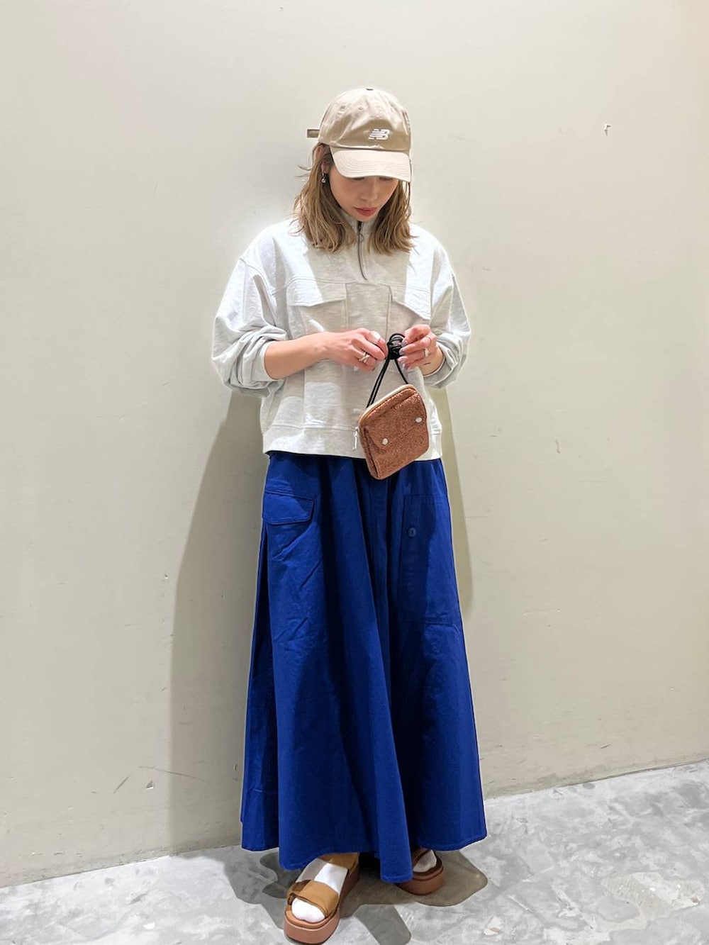 イエロー系のサンダル、ベージュ系のスウェット、オレンジ系のショルダーバッグを着用したレディースの春コーディネートの6枚目の写真