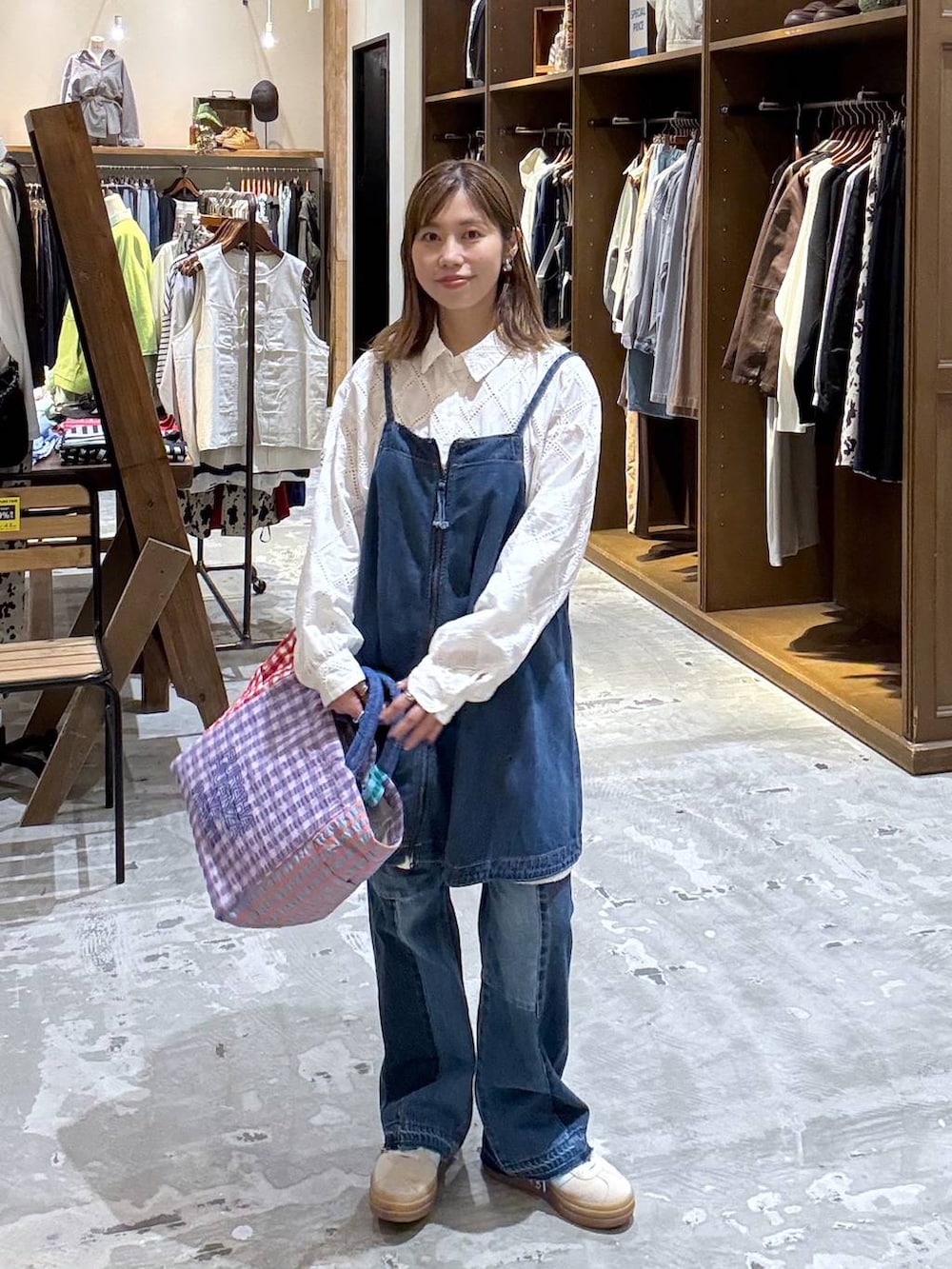 ベージュ系のスニーカー、ブルー系のデニムパンツ、ブルー系のキャミソールを着用したレディースの春コーディネートの6枚目の写真