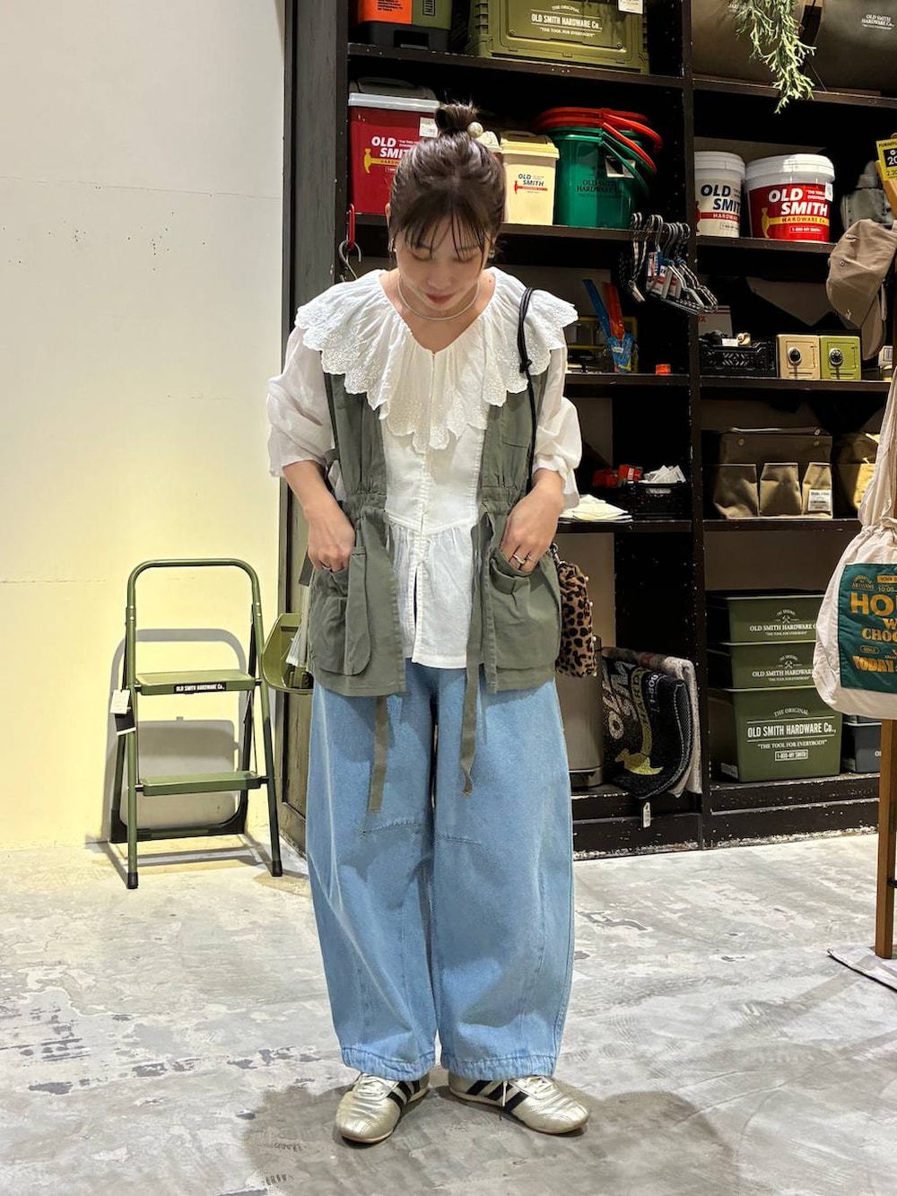 その他のショルダーバッグ、ゴールド系のスニーカー、グリーン系のベストを着用したレディースの冬コーディネートの3枚目の写真